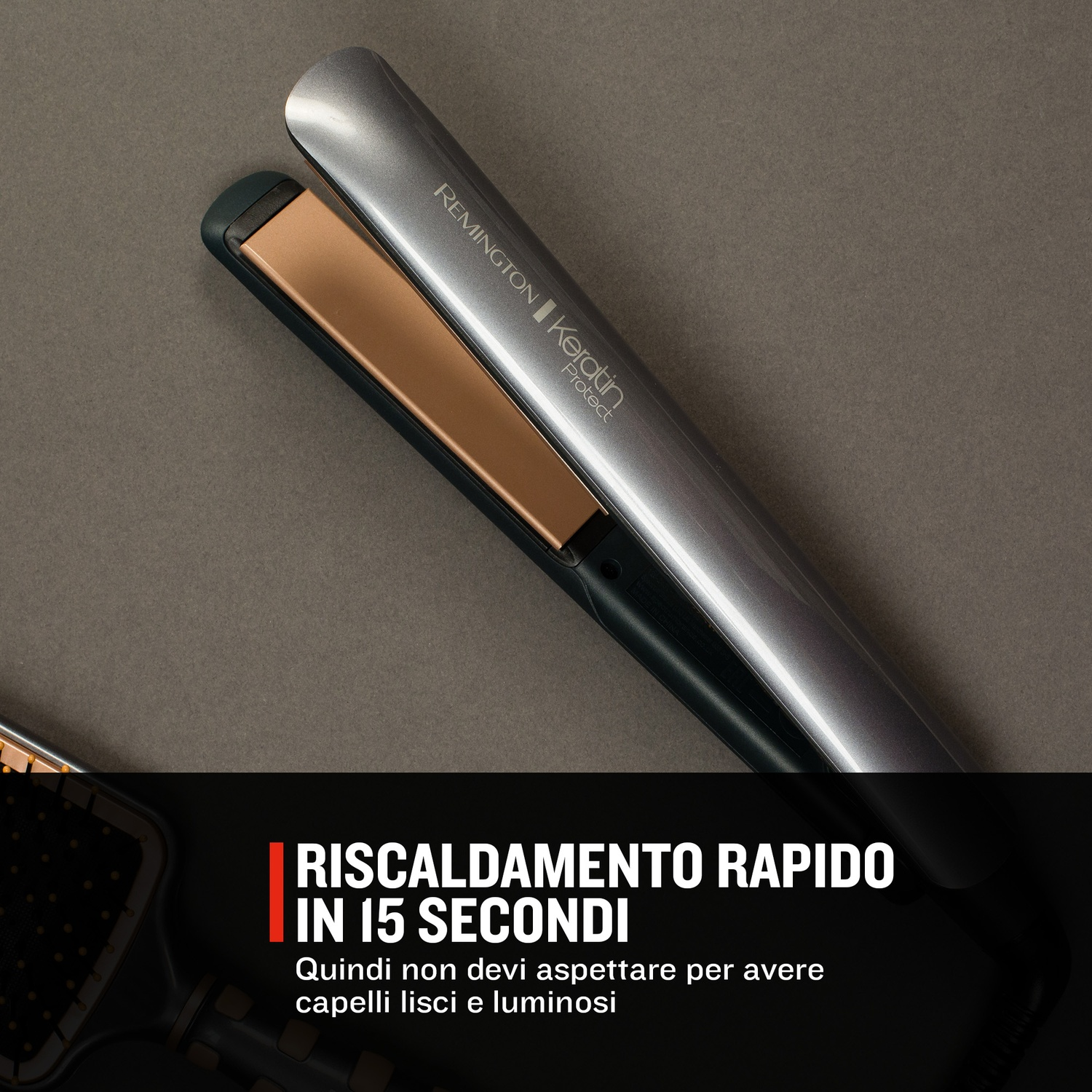 Una piastra per capelli Remington argento con piastre dorate su sfondo grigio.