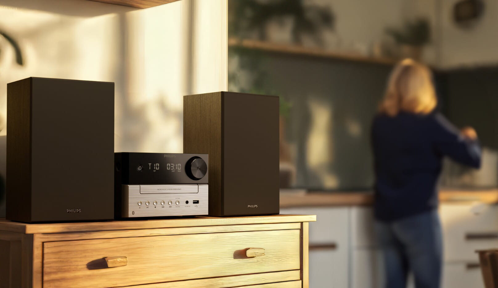 System muzyczny Philips z dwoma głośnikami stoi na drewnianej komodzie.