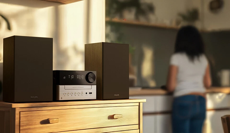 System Hifi Philips z głośnikami i odbiornikiem na drewnianej komodzie.