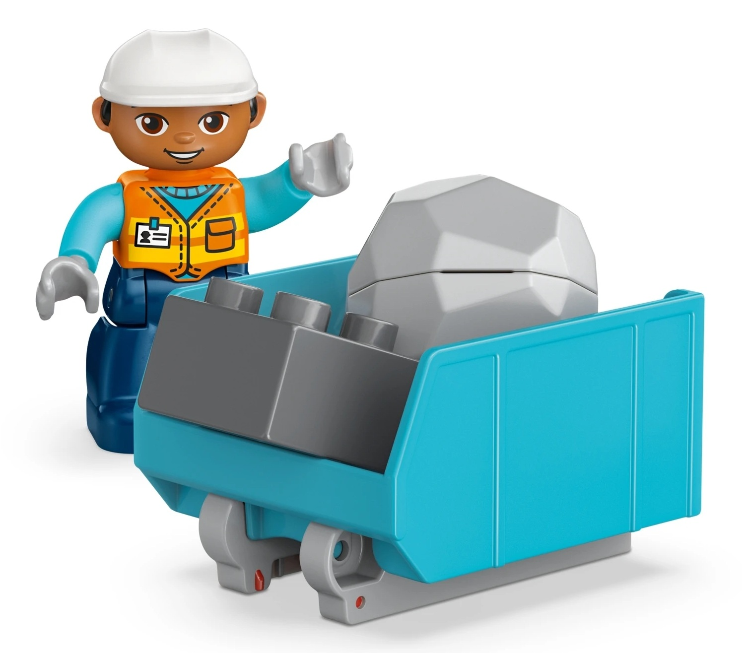 Zabawkowy pracownik budowlany w białym kasku i pomarańczowej kamizelce pcha niebieski wózek ze skałą.