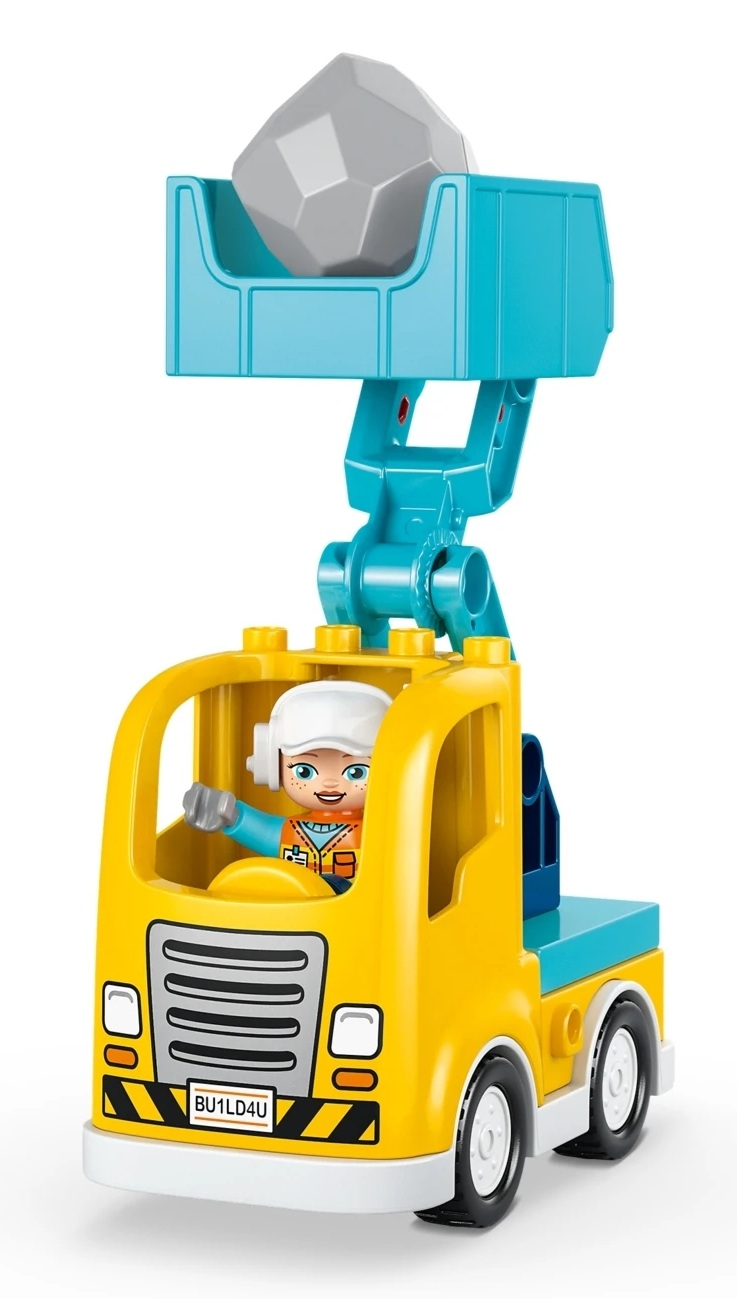 Żółta ciężarówka budowlana z kierowcą i kamieniem w dźwigu.