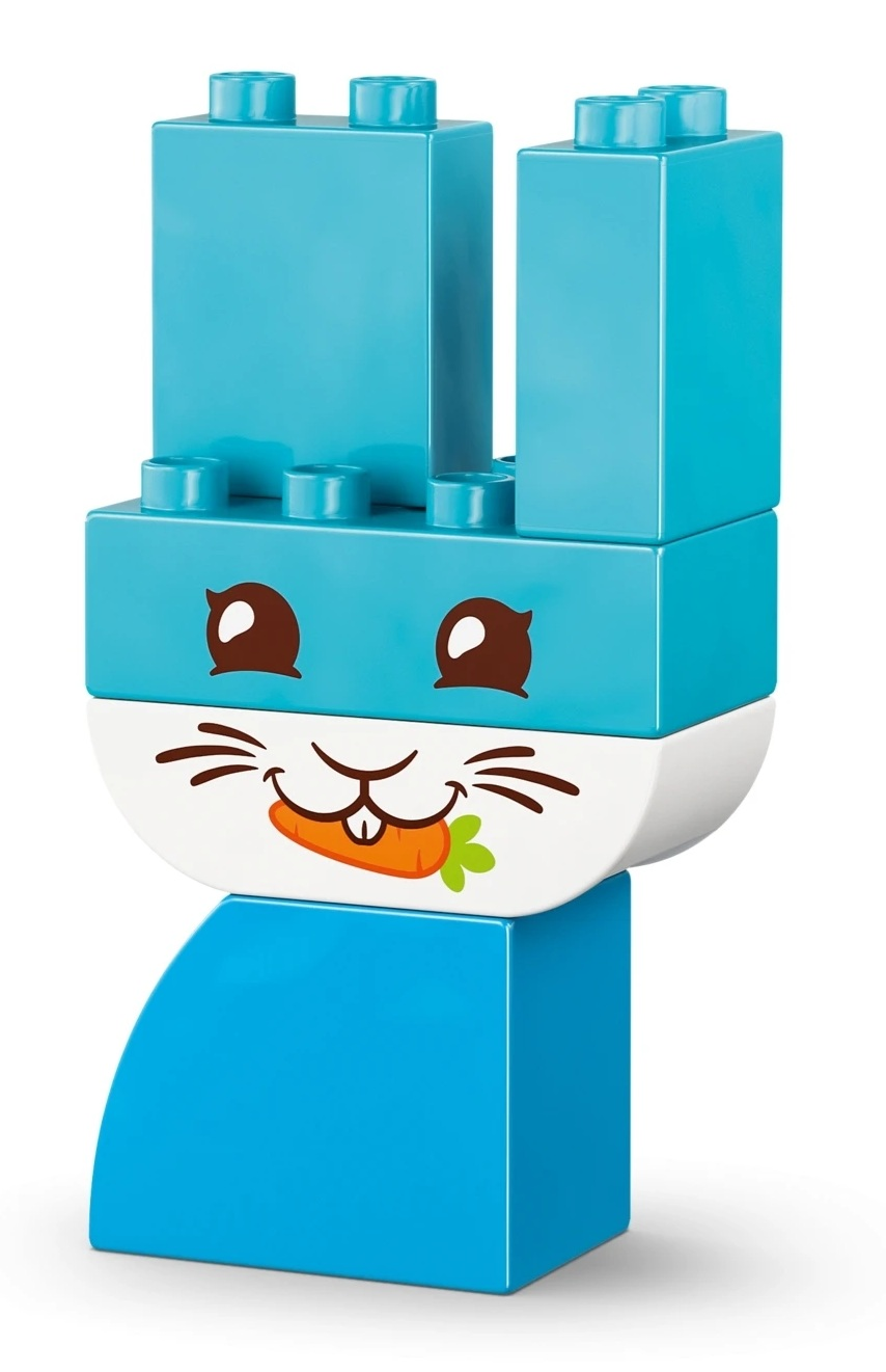 Niebieski króliczek Lego z uszami, oczami i uśmiechem z marchewką.