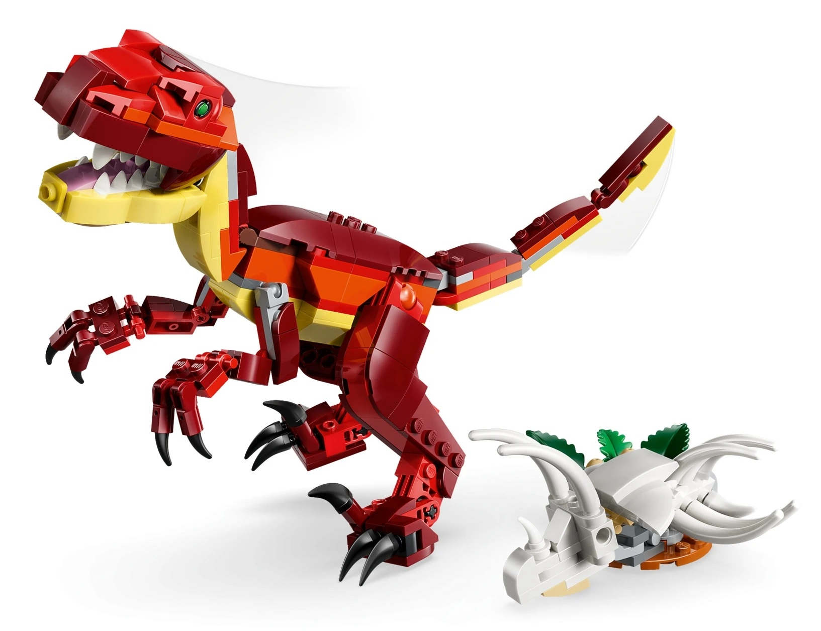 Czerwony dinozaur Lego z żółtym brzuchem stoi obok białej czaszki dinozaura Lego.