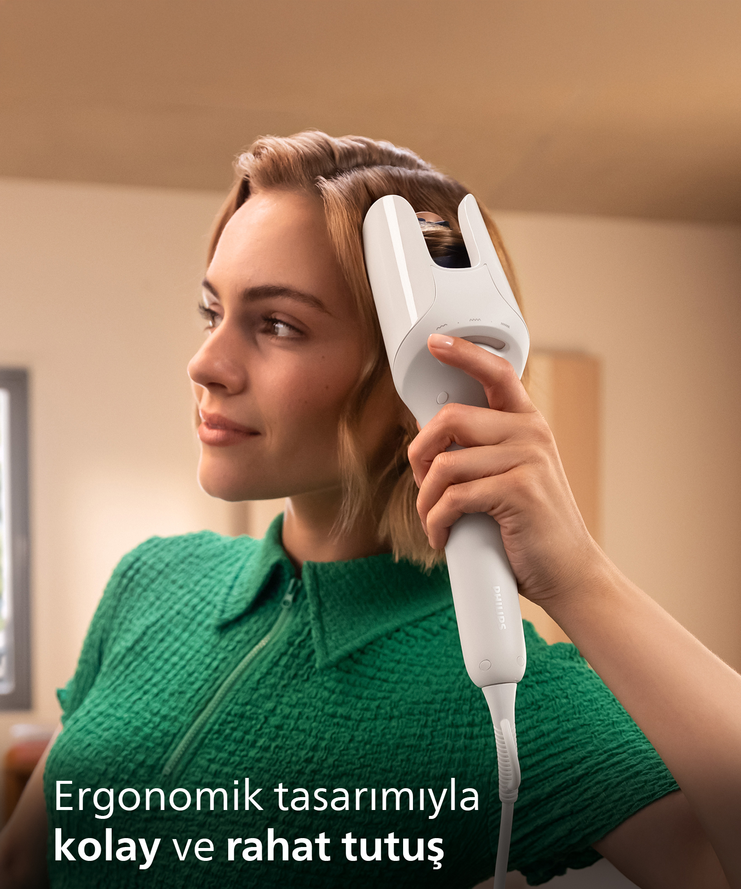 Kısa saçlı bir kadın, saçlarına beyaz bir saç kurutma makinesi kullanıyor.