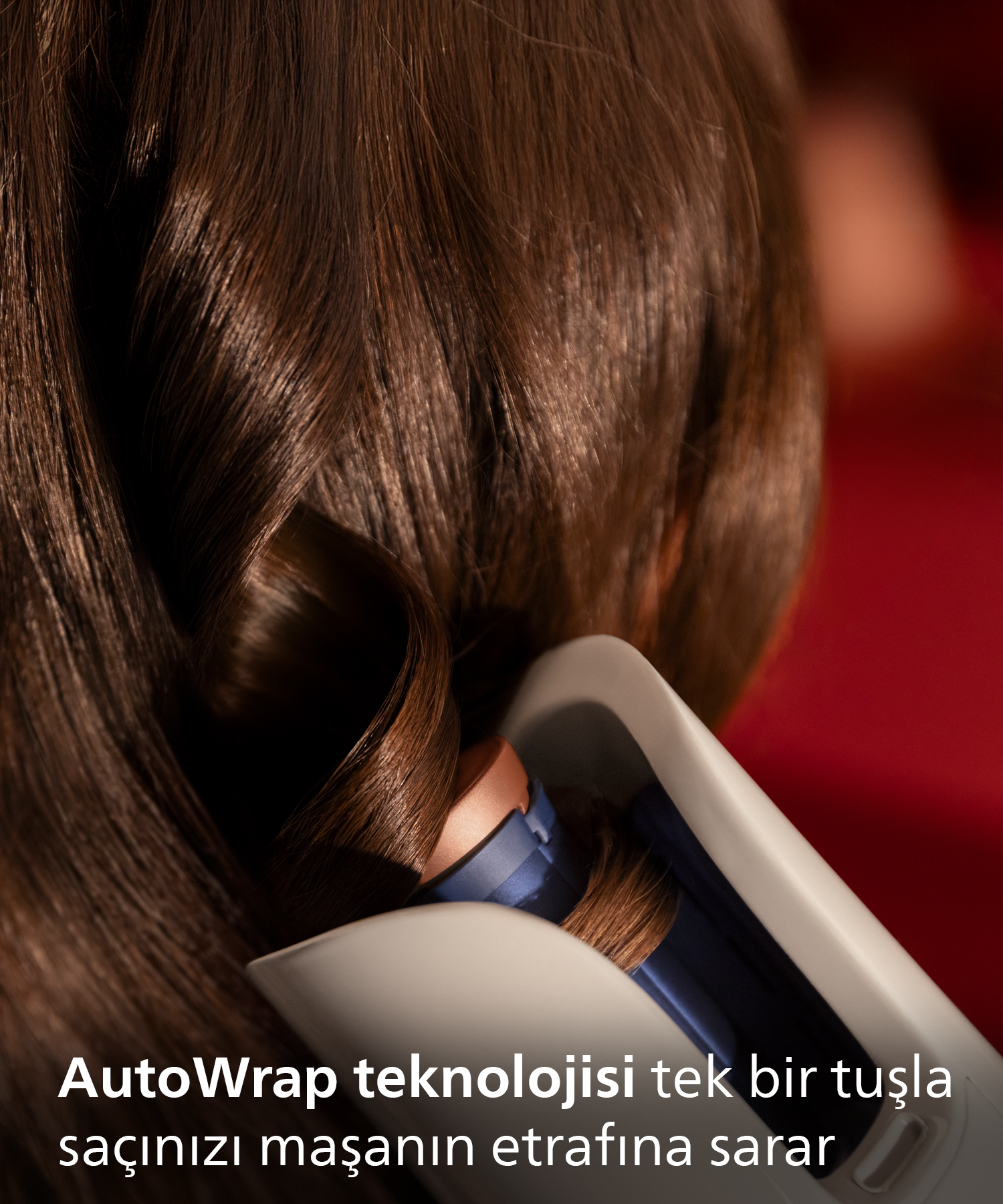 Kahverengi saçlar, saçı etrafına saran otomatik bir maşa ile kıvrılıyor.