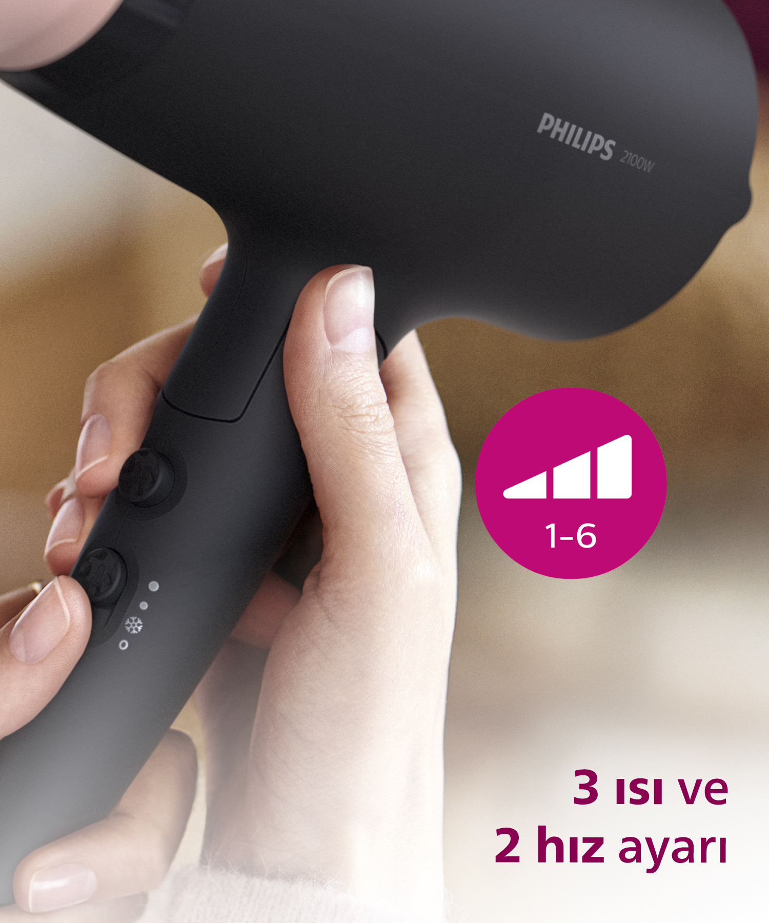 Siyah Philips 2100W saç kurutma makinesi elde, hız/ısı ayarları gösteriliyor.