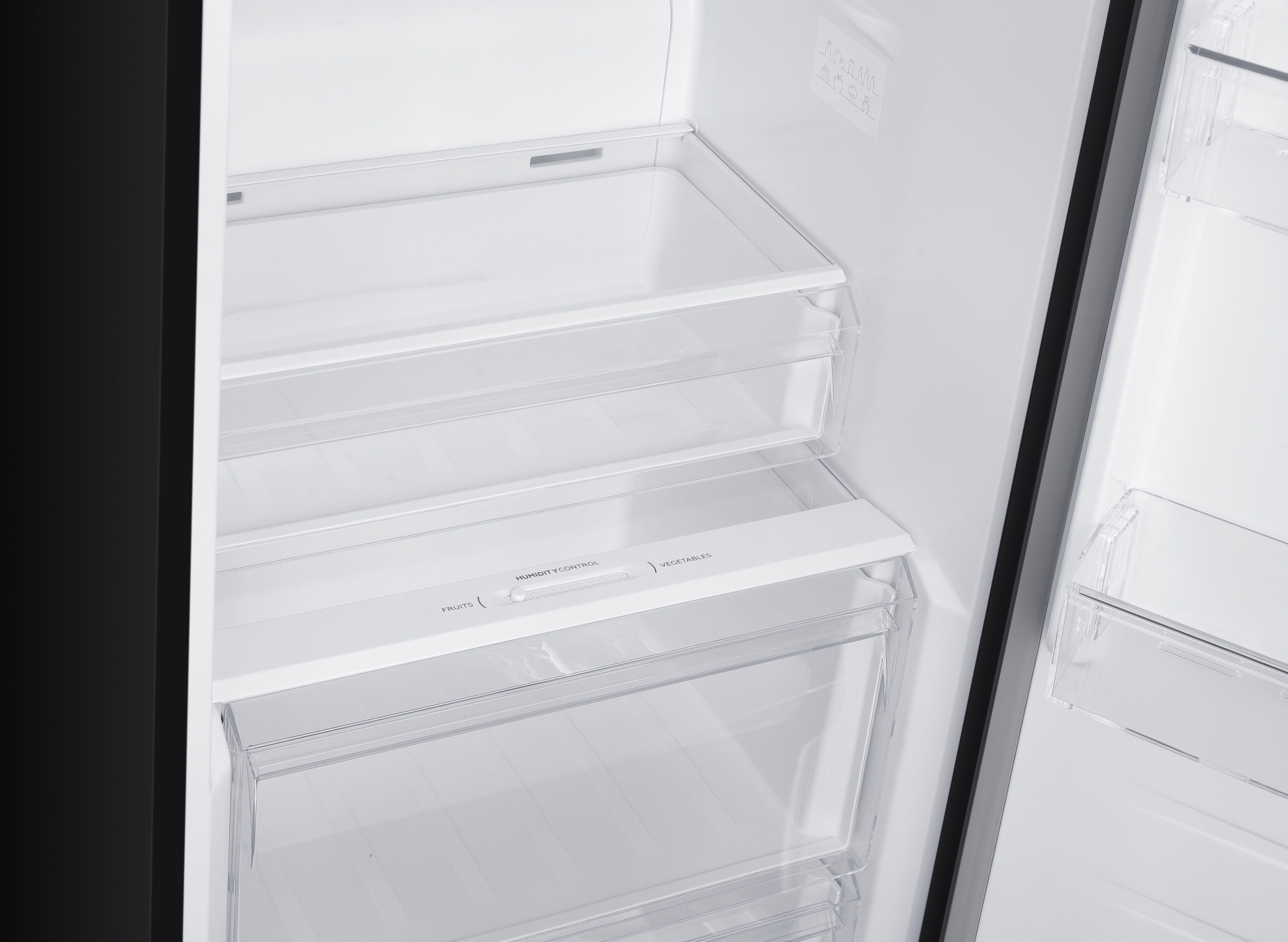 Innenansicht eines Kühlschranks mit transparenten Schubladen und Regalen.