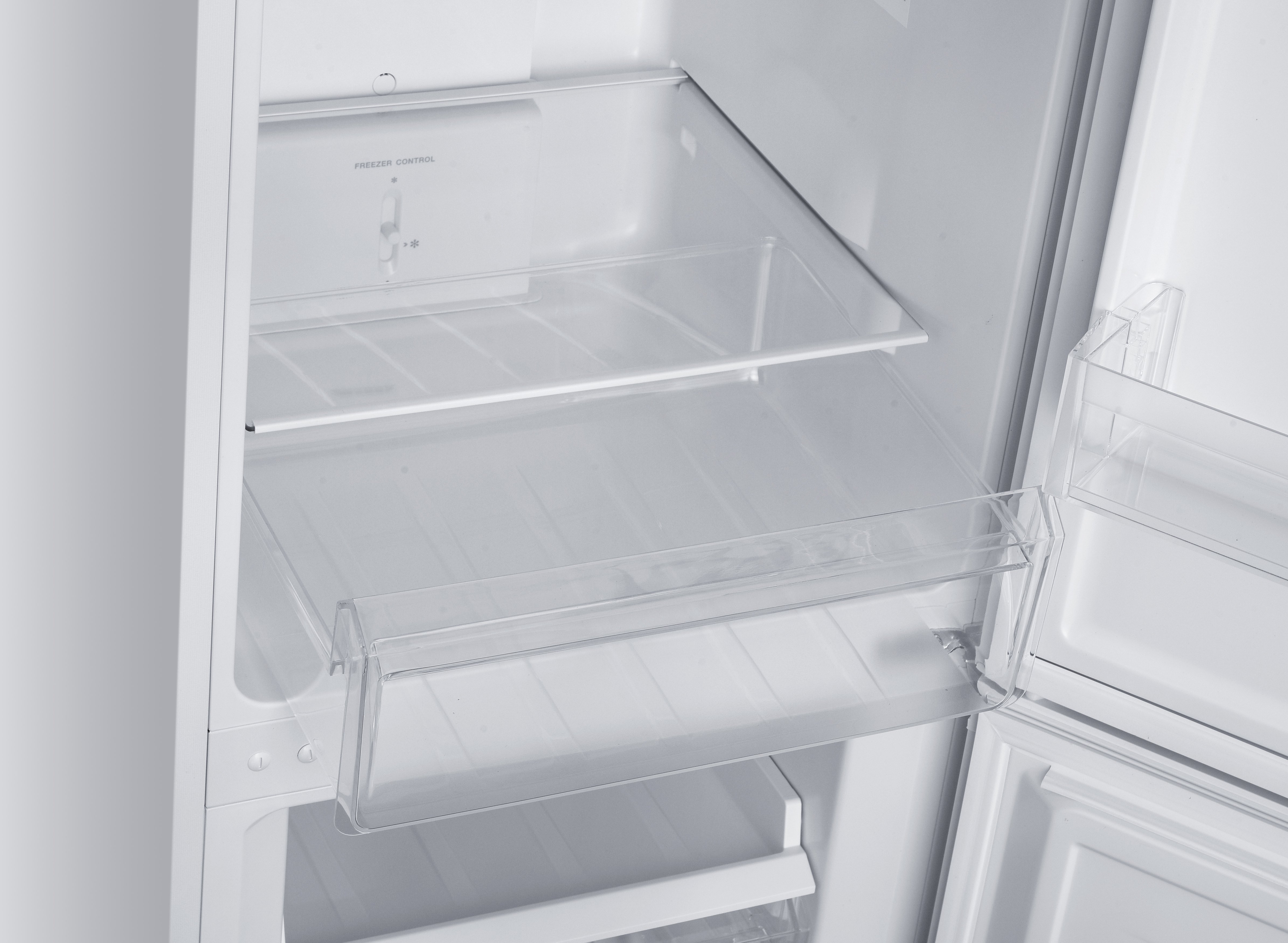 Innenansicht eines leeren weißen Kühlschranks mit Glasböden und Gefrierfachsteuerung.