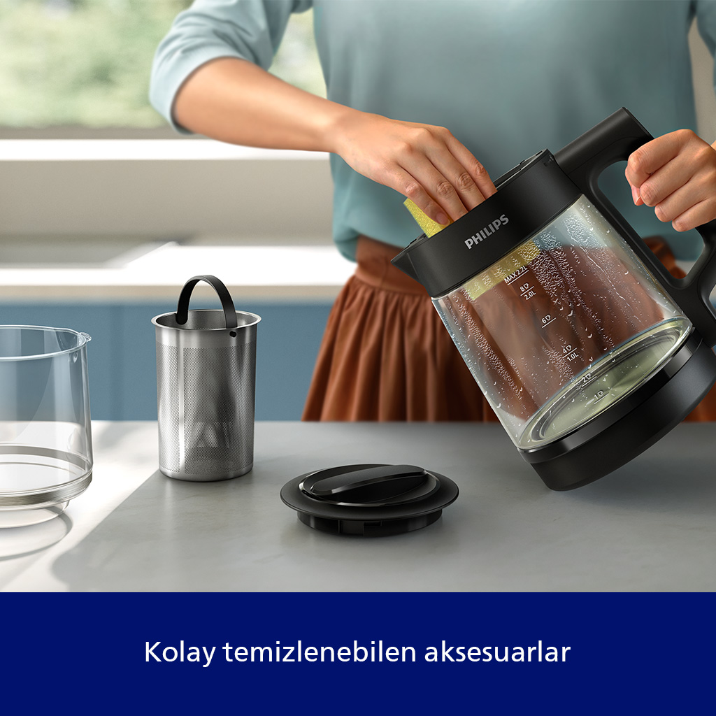 Kişi sarı süngerle cam demliği temizliyor. Aksesuarlar yakında.