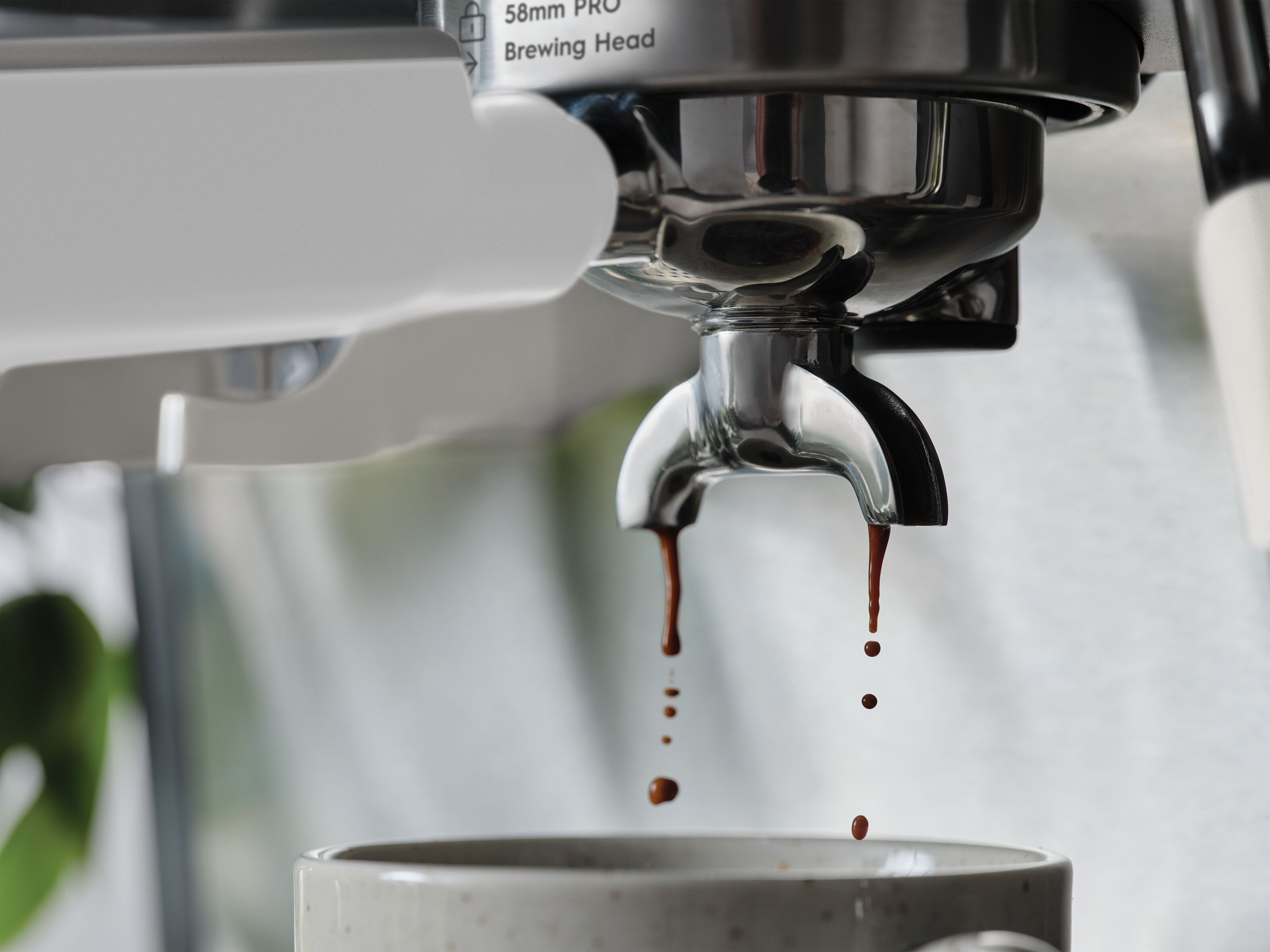 Taze demlenmiş espresso, kahve makinesinden bir fincana damlıyor.