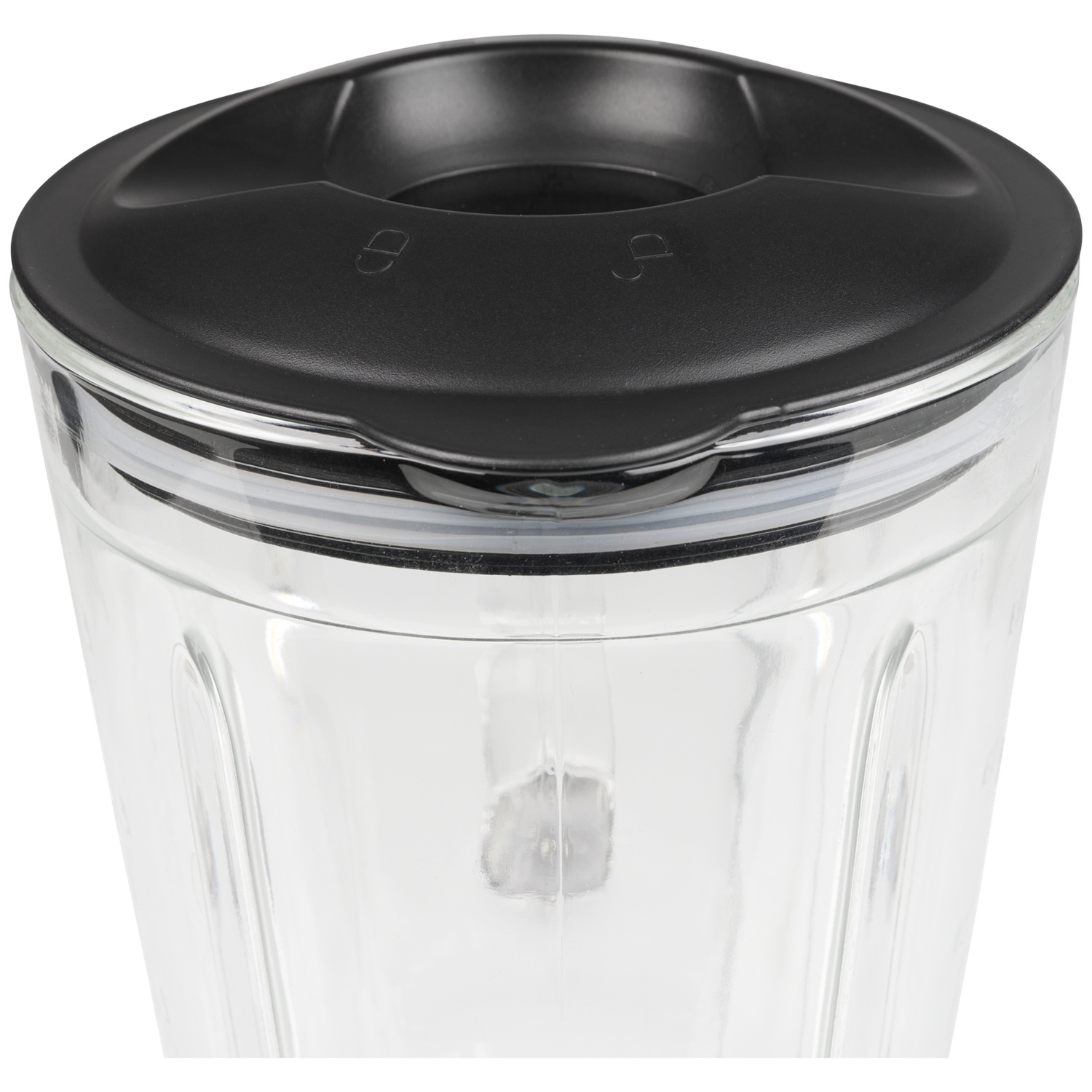 Close-up of a clear glass blender jar with a black lid. The lid has markings.