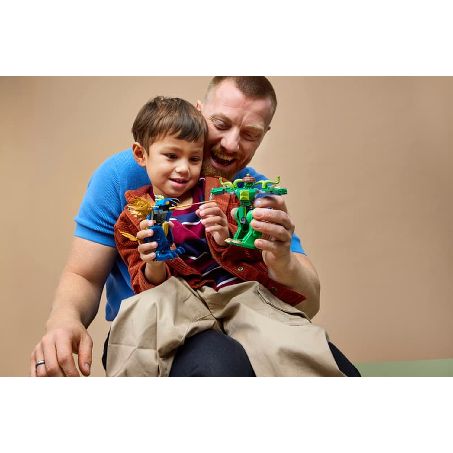 Man and child hold colorful toy robots, smiling.