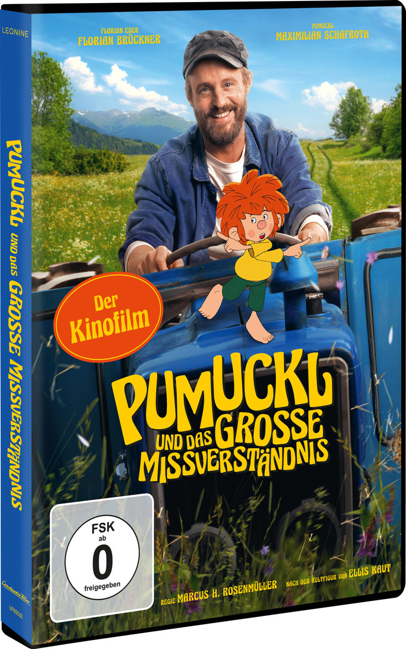 Ein Mann auf einem Traktor mit Pumuckl. Berglandschaft im Hintergrund.