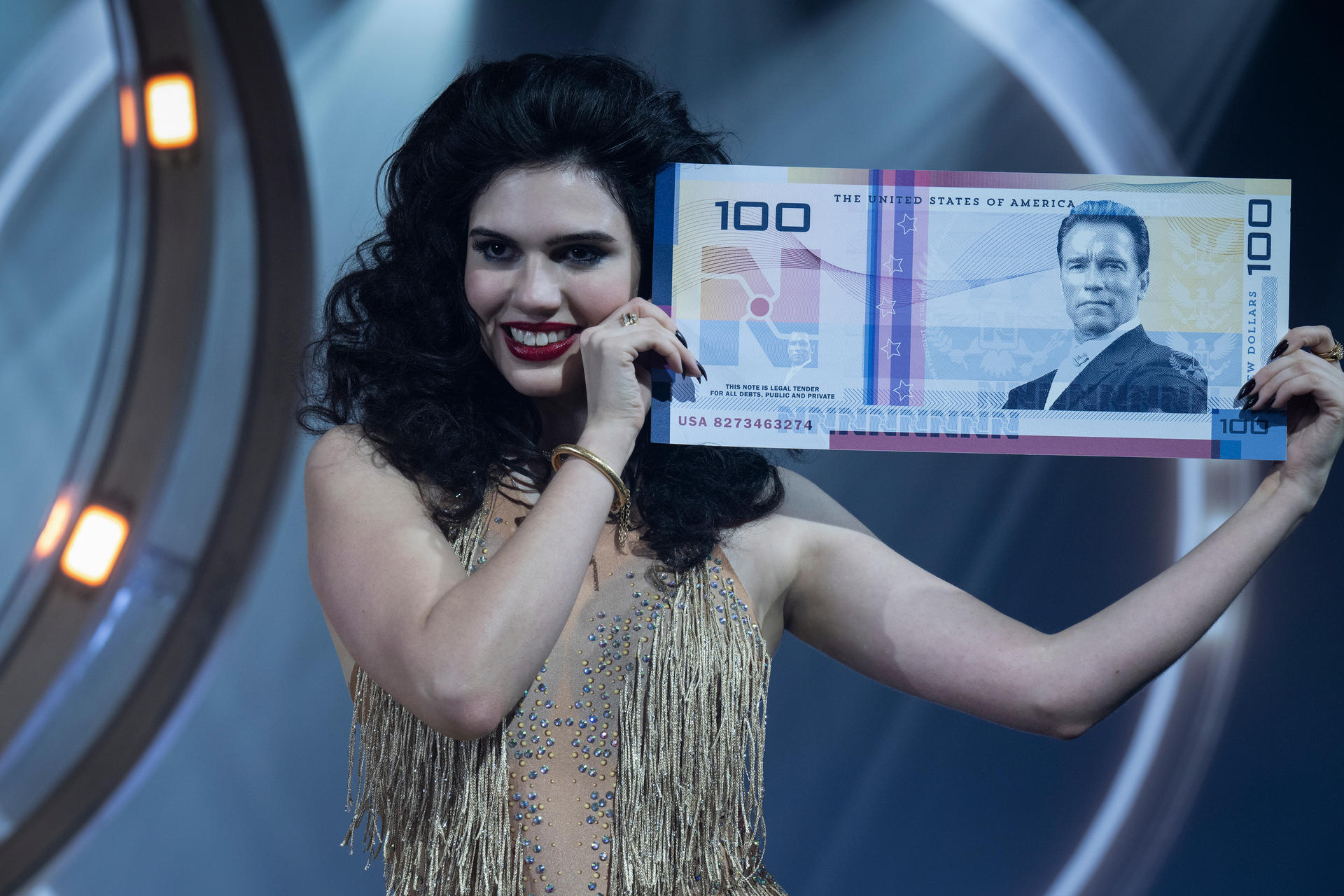 Frau mit dunklen Haaren hält eine 100-Dollar-Note mit Arnold Schwarzenegger.