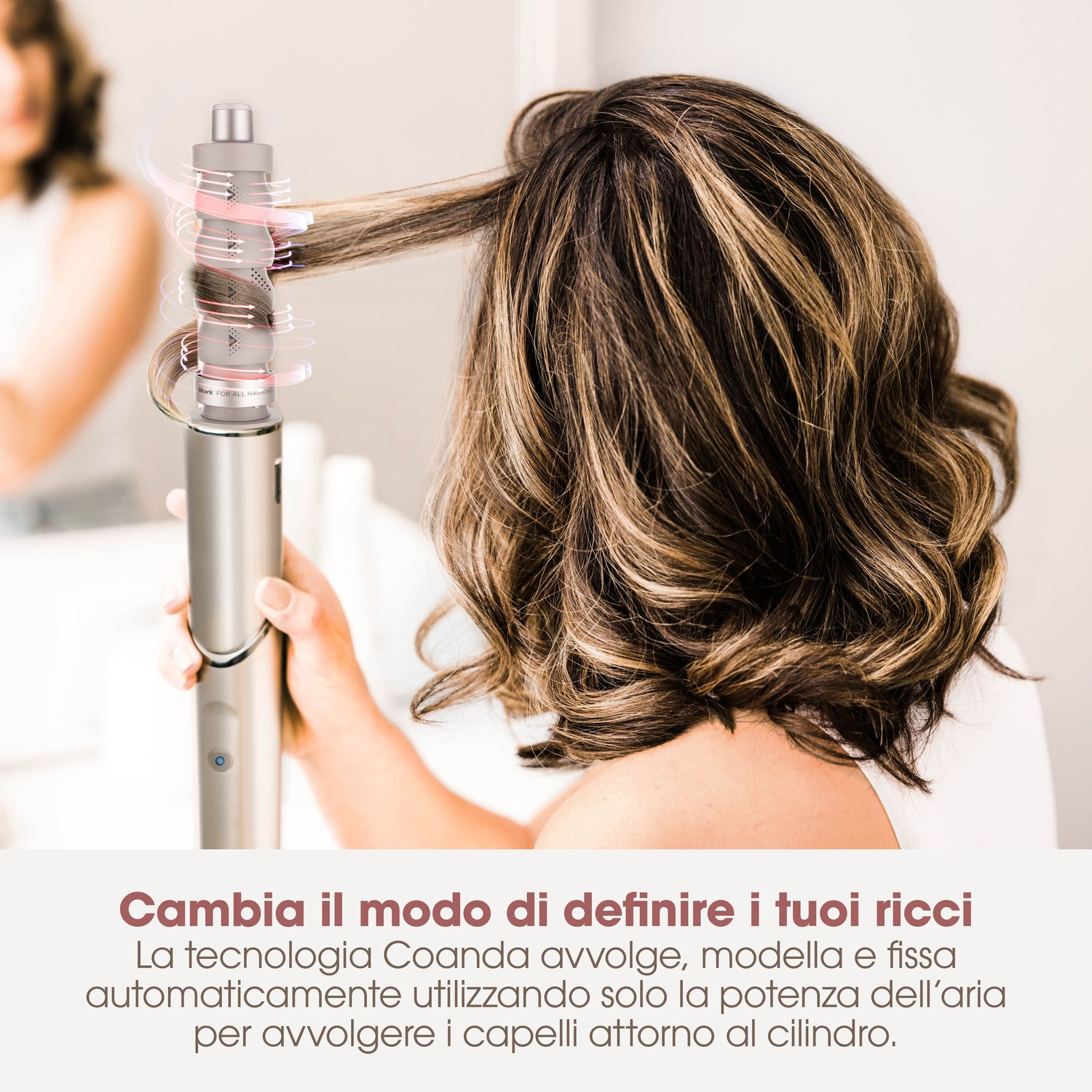 Donna acconcia capelli castani con arricciacapelli ad aria. Primo piano.