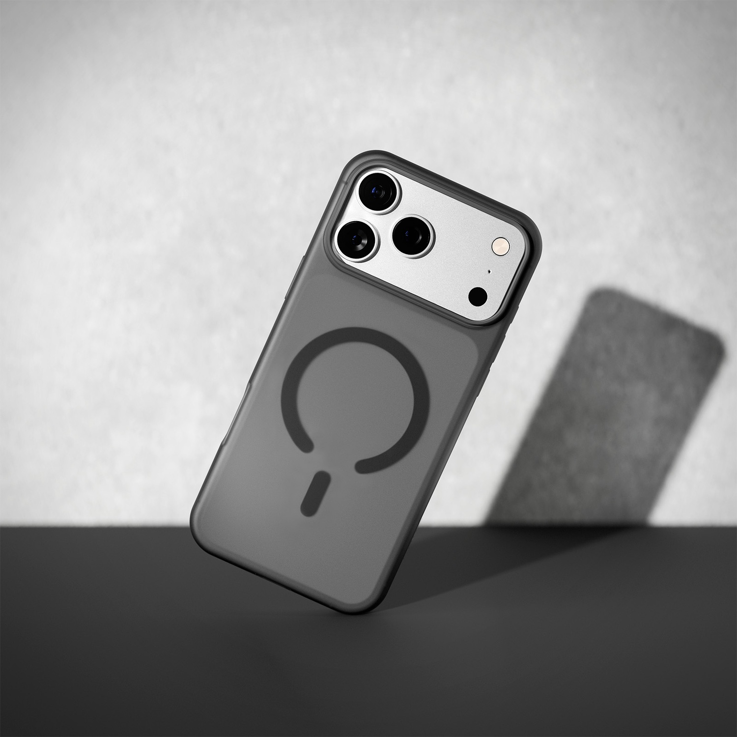 Coque de téléphone grise avec symbole d'anneau magnétique, flottant devant un fond.