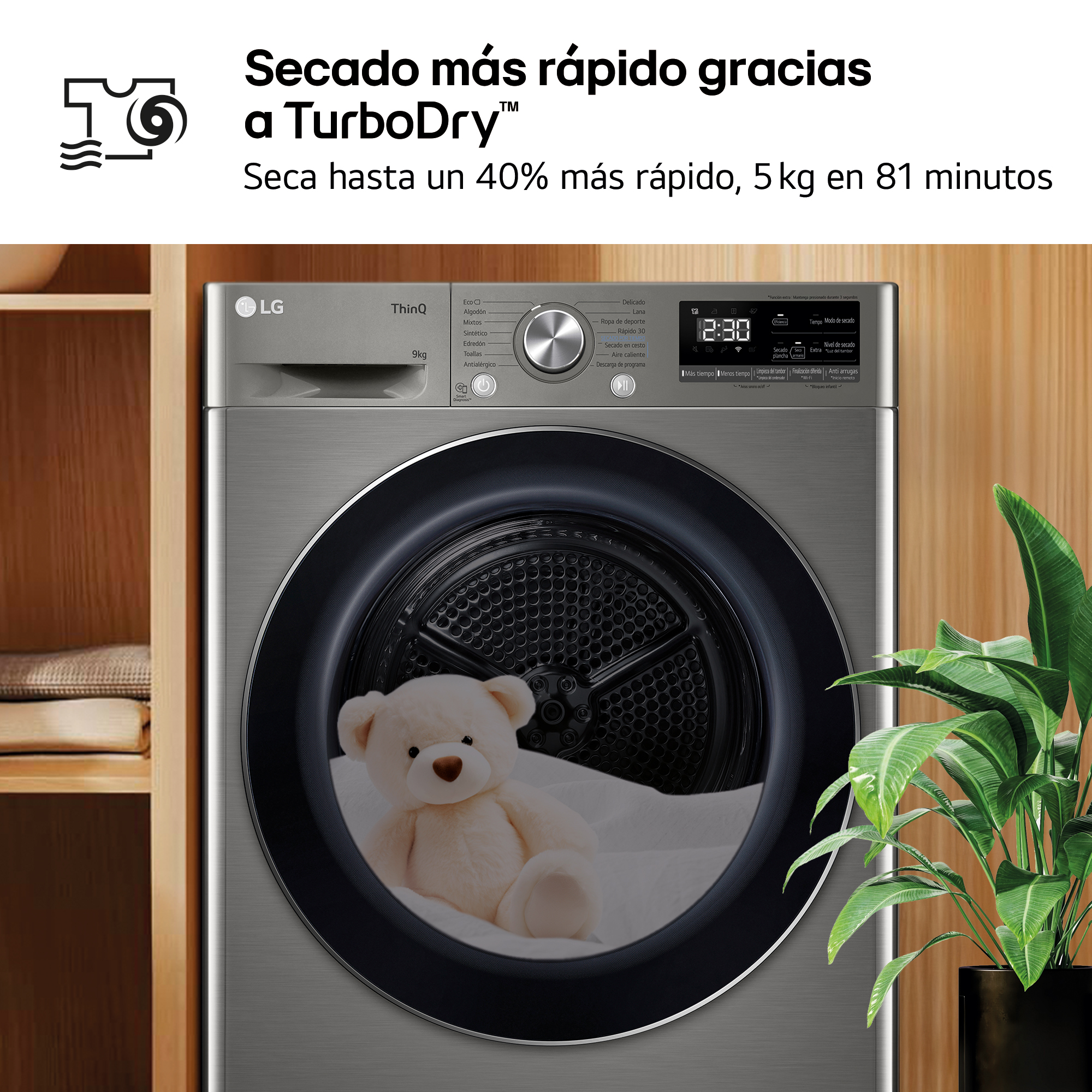Secadora LG gris con un osito de peluche dentro, junto a una planta.