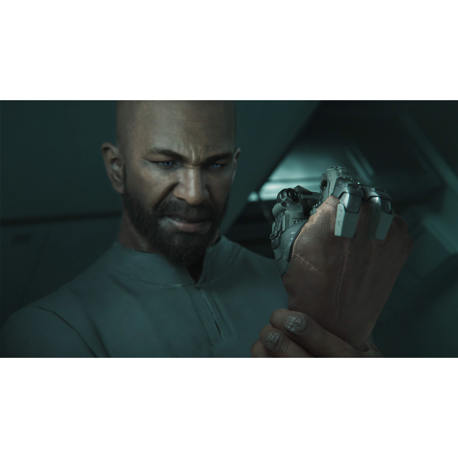 Een kale man met baard bekijkt een mechanische prothesehand.