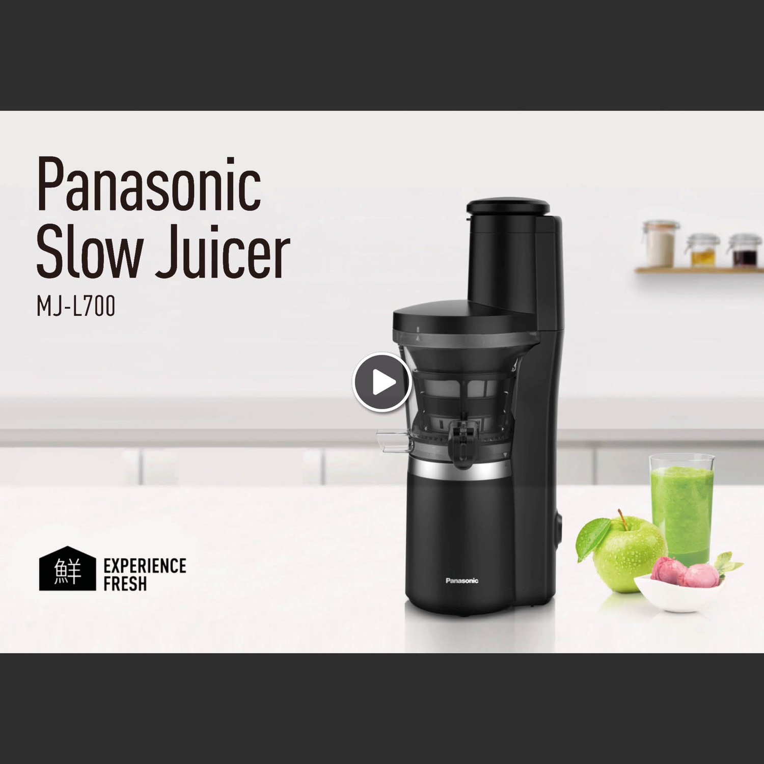 Centrifuga lenta Panasonic nera con bicchiere di succo, mela e ciotola sul tavolo.
