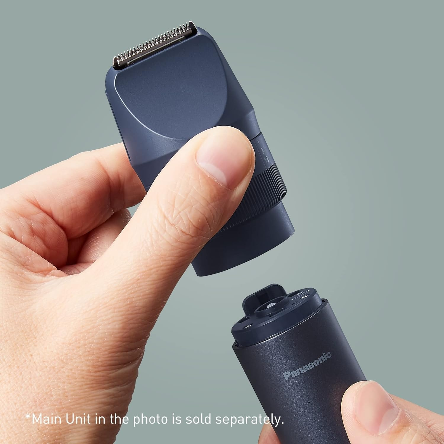 Primo piano: Mani che assemblano un accessorio per rifinitore Panasonic blu scuro. Sfondo grigio.