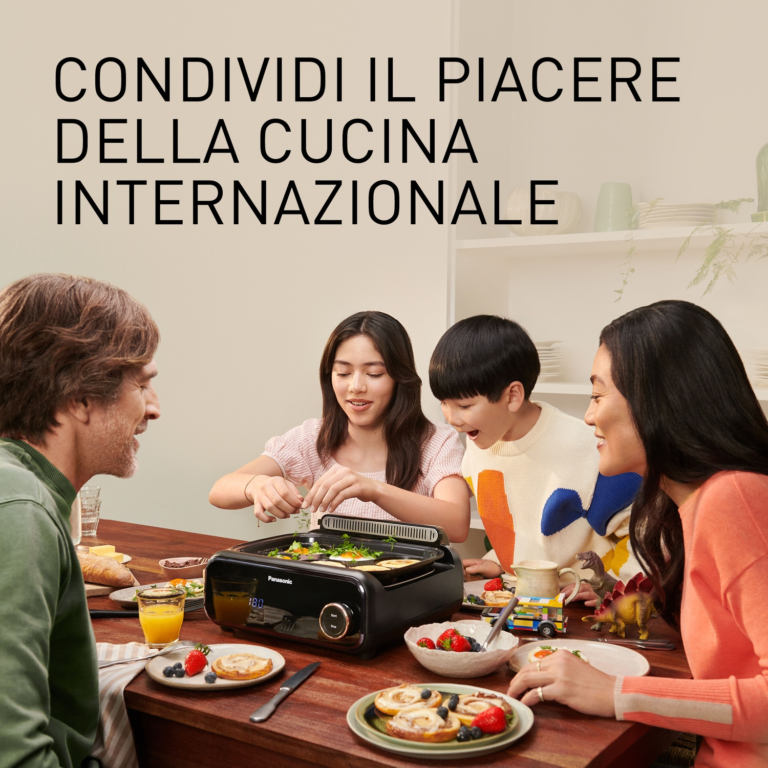 Famiglia gusta cucina internazionale. Uomo, due bambini, donna a tavola.