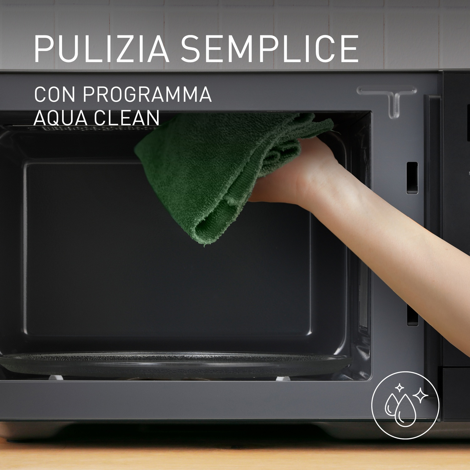 Una mano pulisce un microonde con un panno verde. Pulizia semplice.