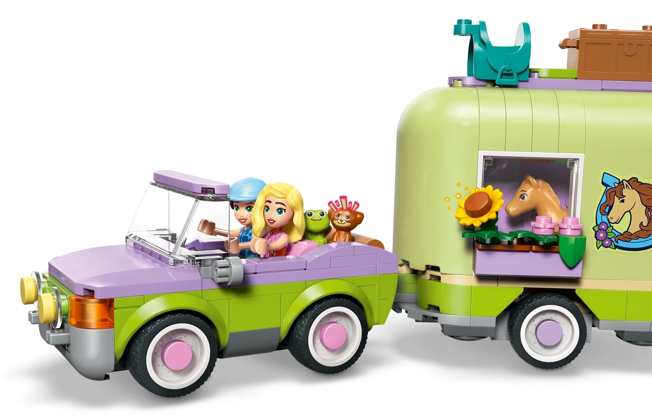 Figurki Lego w samochodzie ciągnącym przyczepę z koniem.