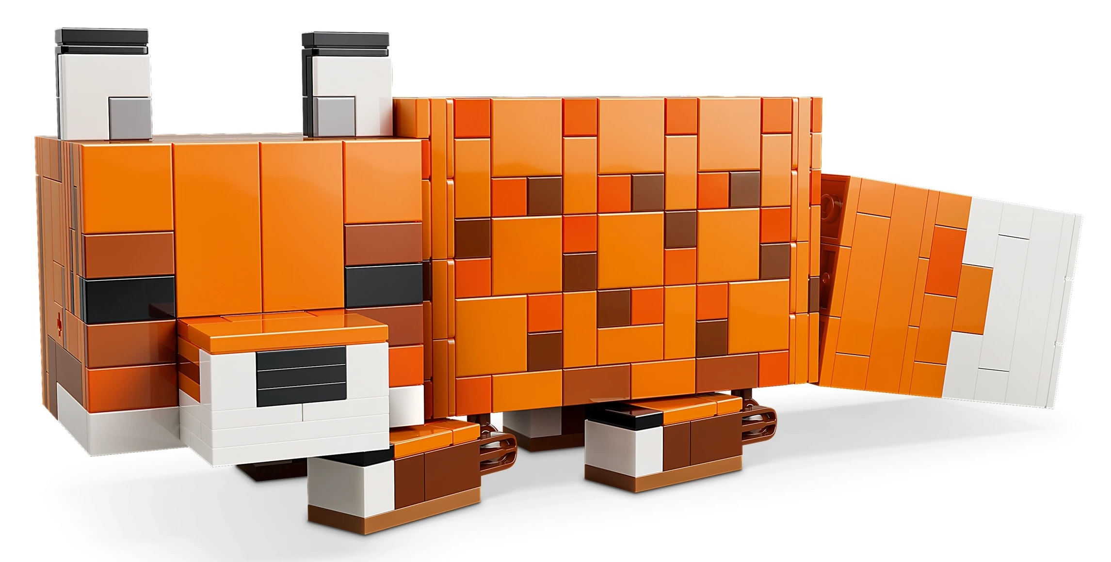 Pomarańczowy lis zbudowany z klocków Lego z białymi i brązowymi akcentami.