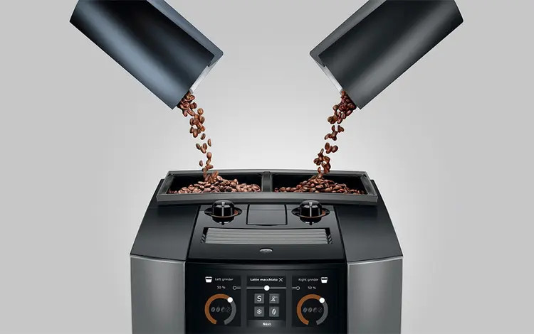 Ziarna kawy spadają z dwóch pojemników do maszyny.