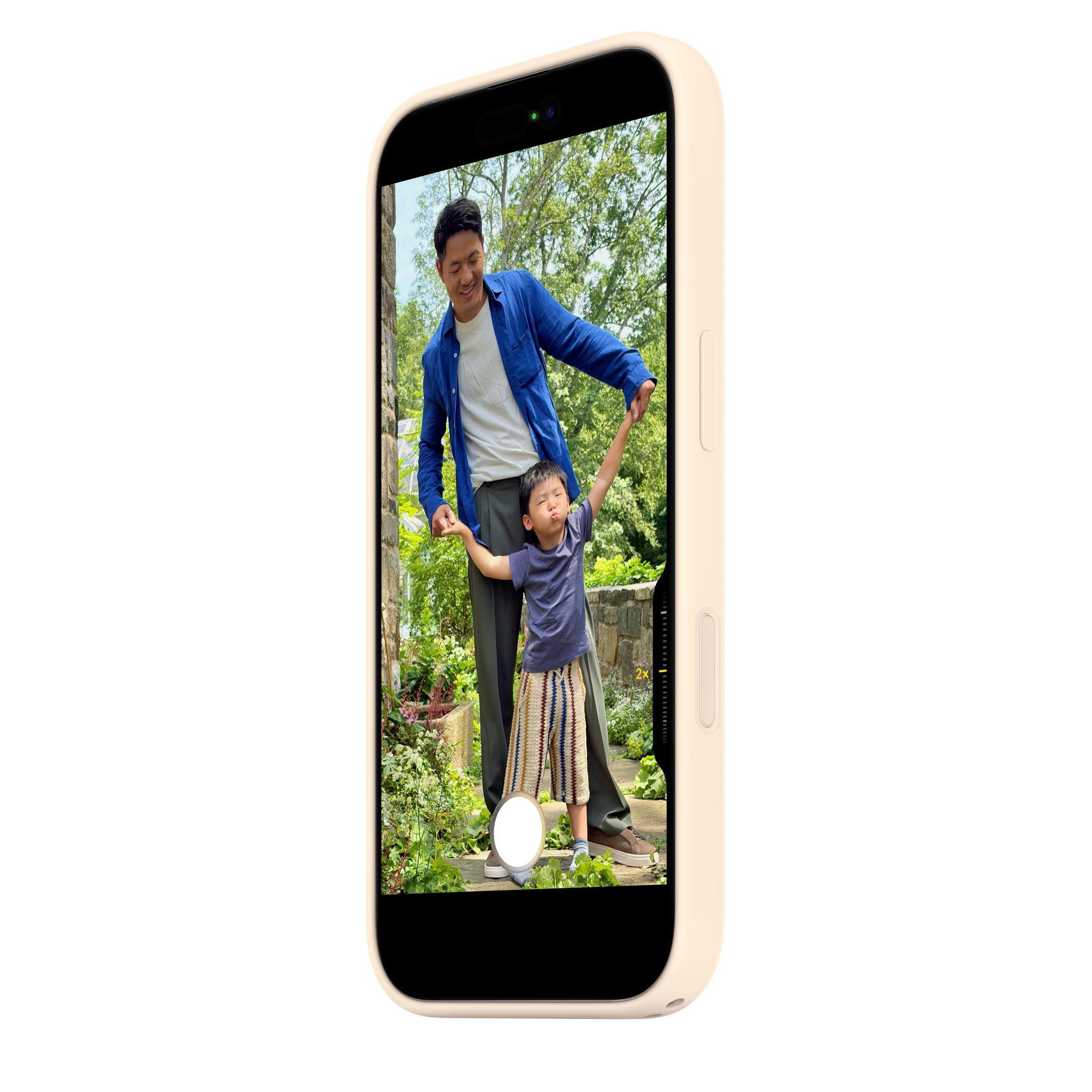 Mann hält Kind an den Händen in einem Garten, aufgenommen mit einem Handy.