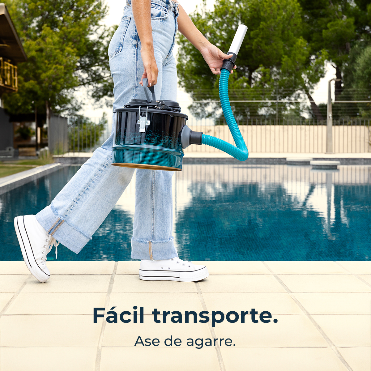 Persona con bidón y manguera de limpiafondos junto a piscina.
