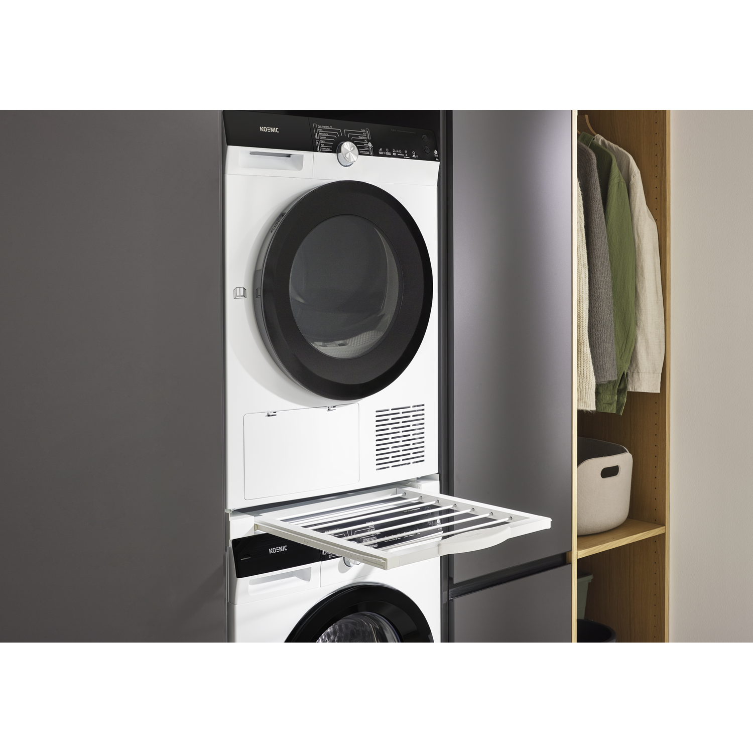 A white dryer stacked on a washing machine with its drying rack extended.
