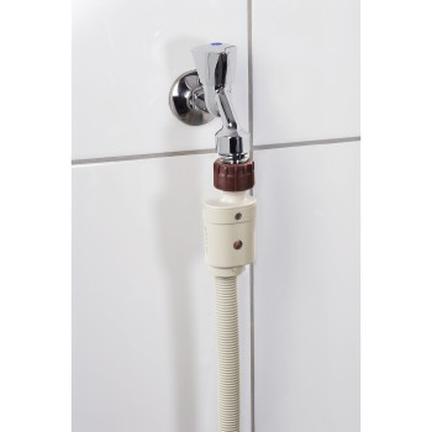 Een kraan met beige slangadapter op een witte tegelmuur.