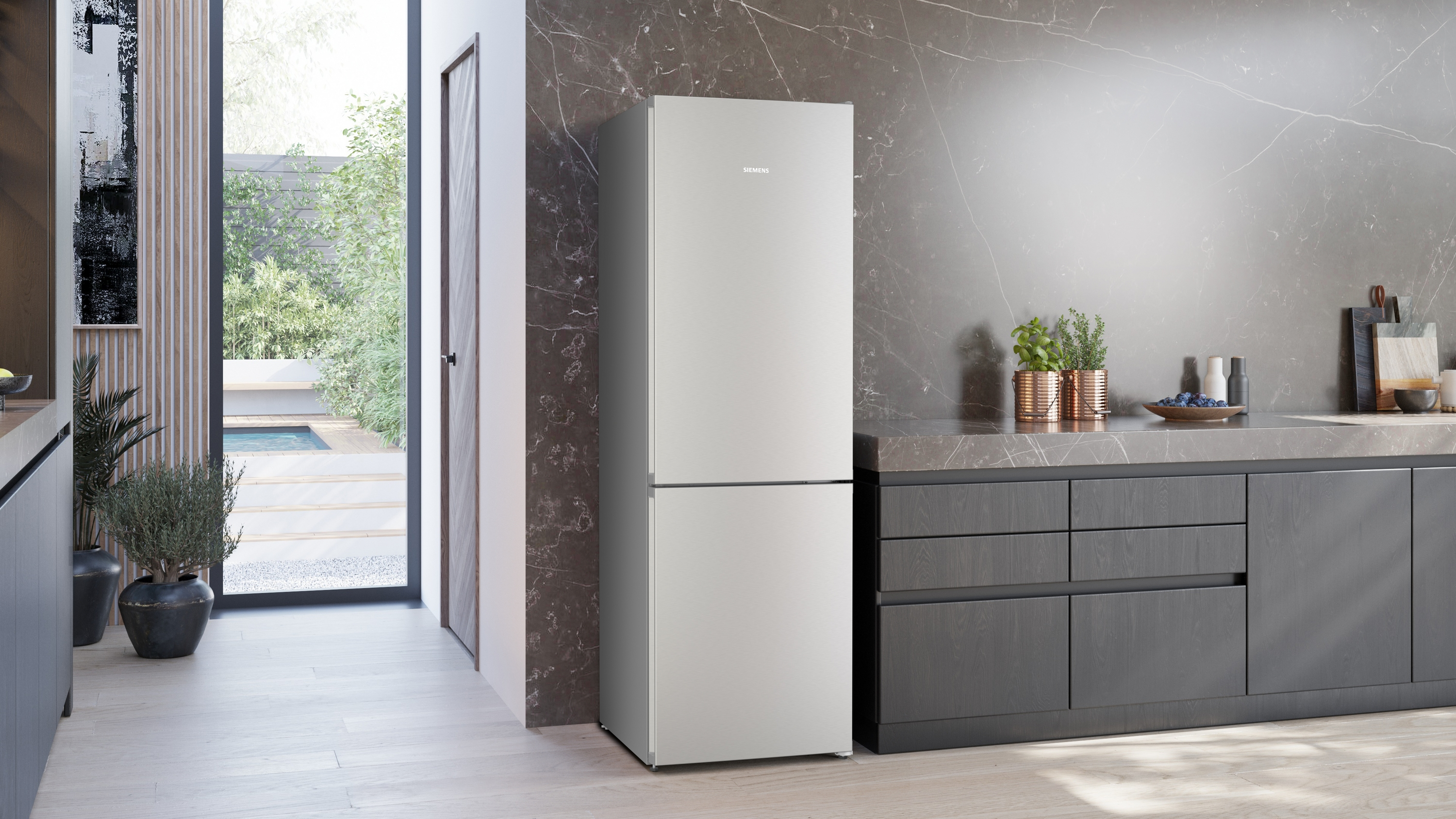 Ein moderner grauer Kühlschrank steht in einer stilvollen Küche mit Marmorrückwand.