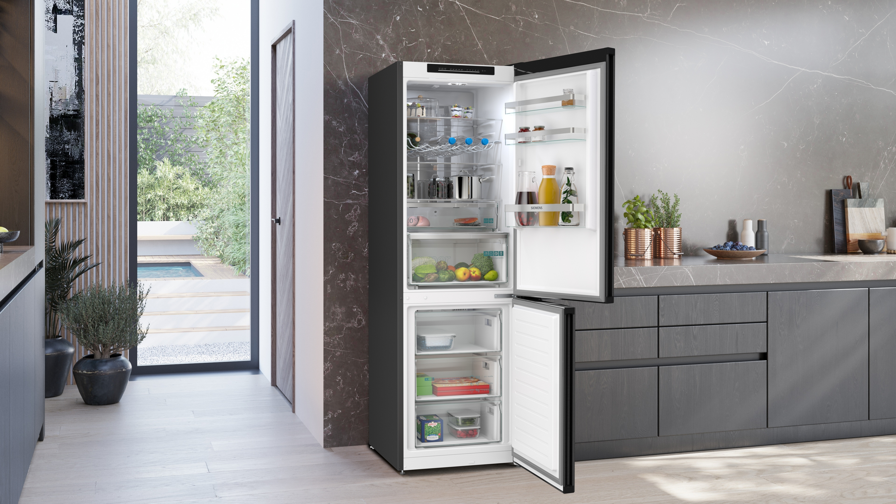 Ein offener Kühlschrank mit Lebensmitteln, daneben eine Küchenzeile und ein Garten.