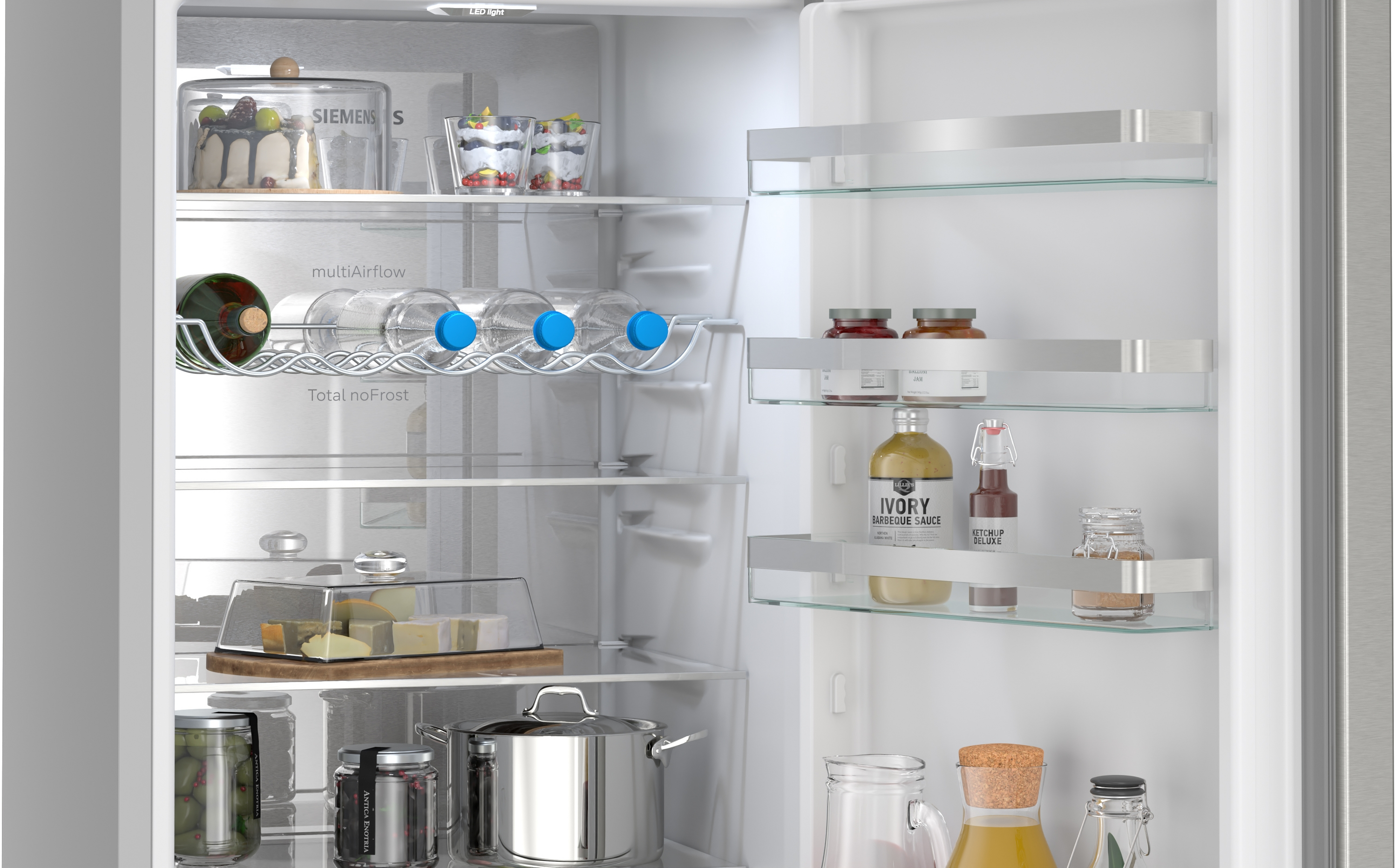 Kühlschrank mit Kuchen, Obst, Flaschen und Lebensmitteln.