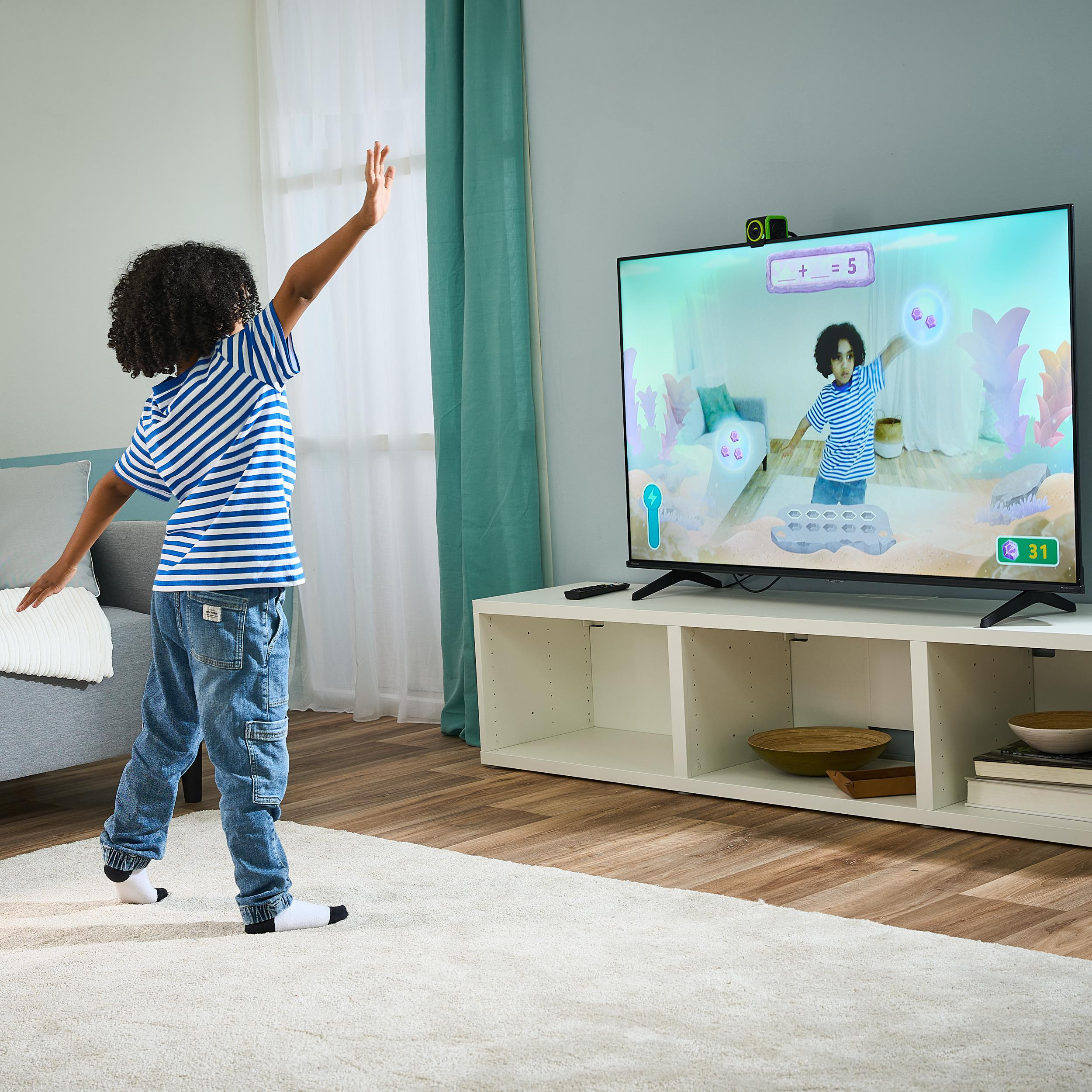 Kind spielt Videospiel, hebt Arme, blickt auf Bildschirm mit Spiel.