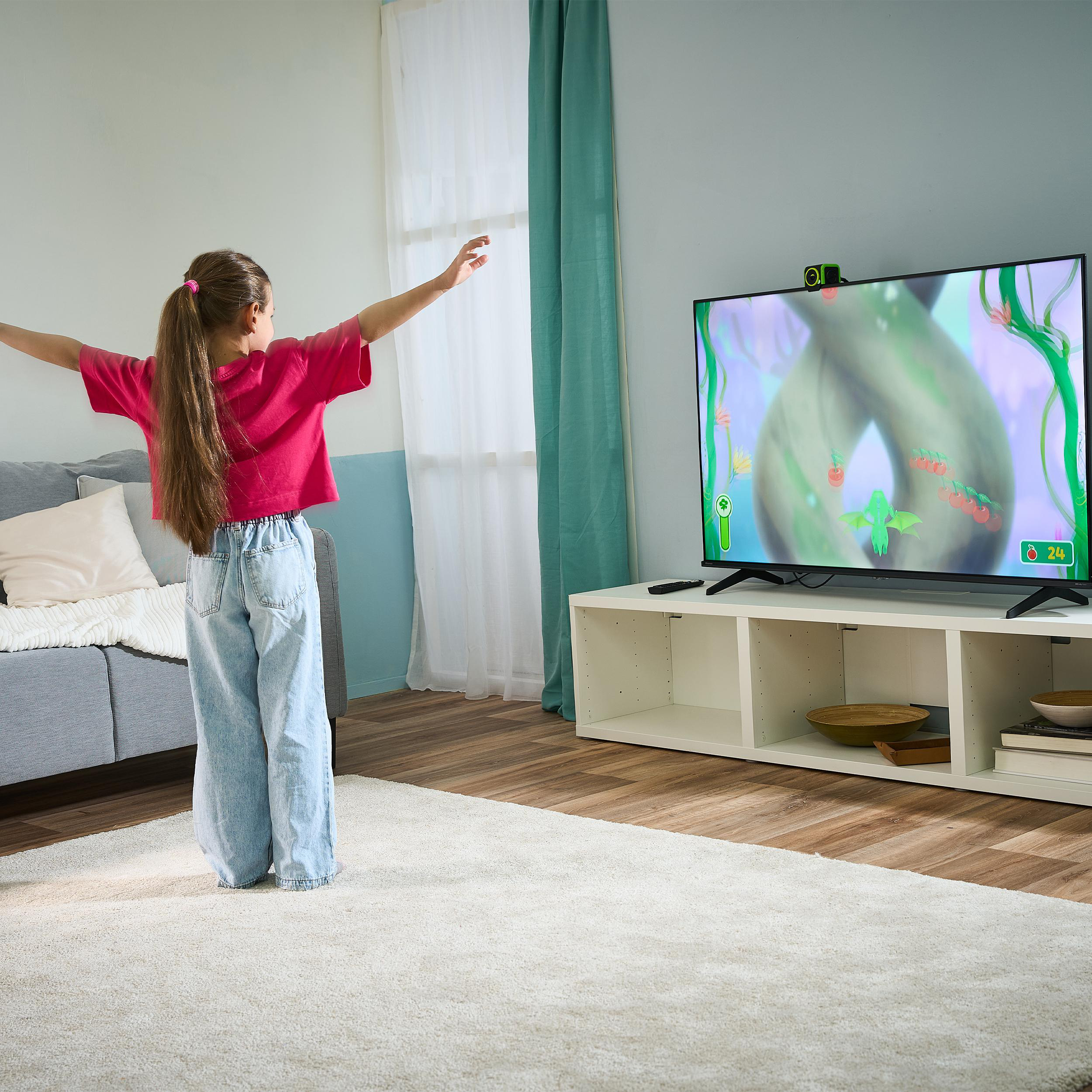 Mädchen mit Zopf spielt ein Videospiel auf dem Fernseher in einem Wohnzimmer.