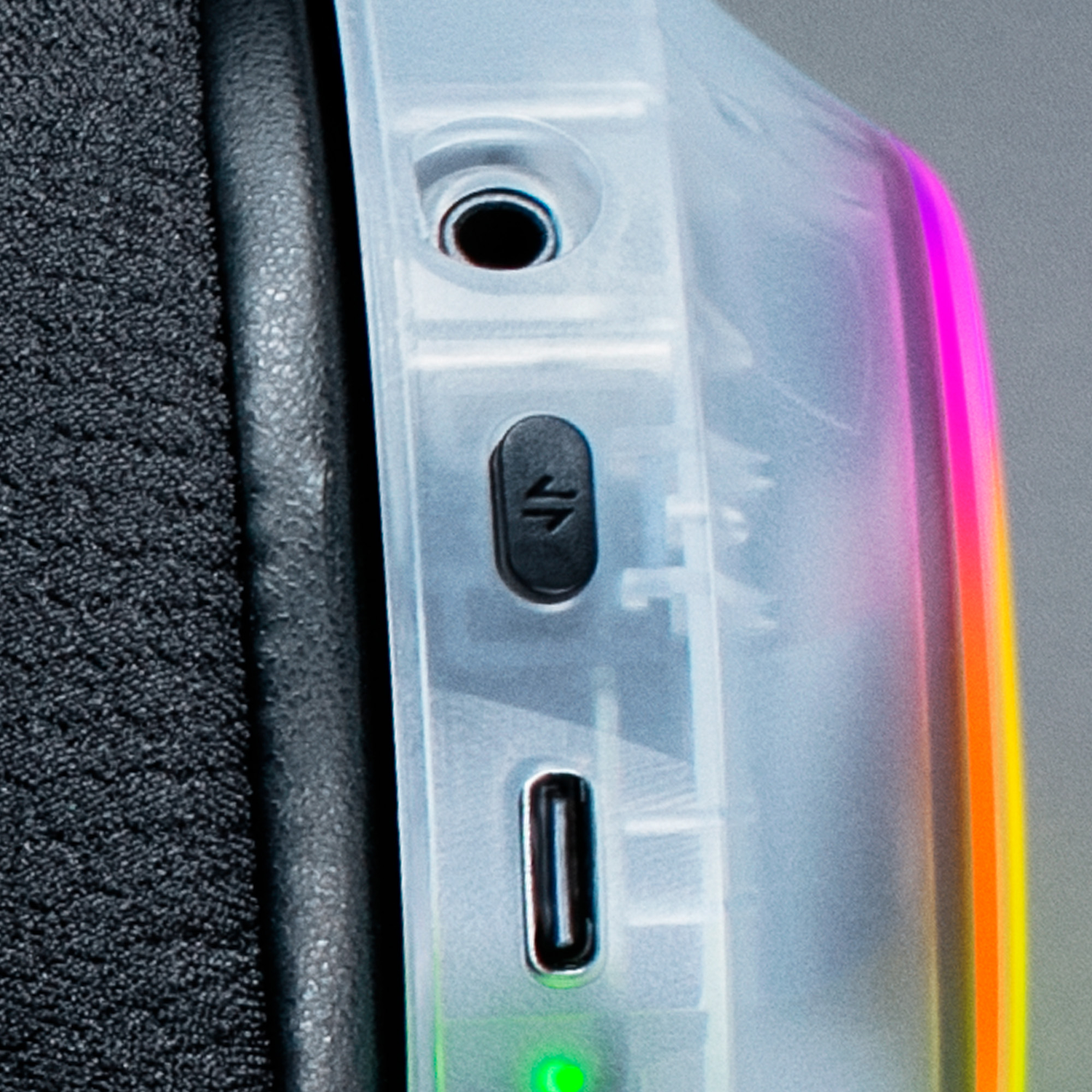 Close-up of headphones showing USB-C port, button, and RGB lighting.