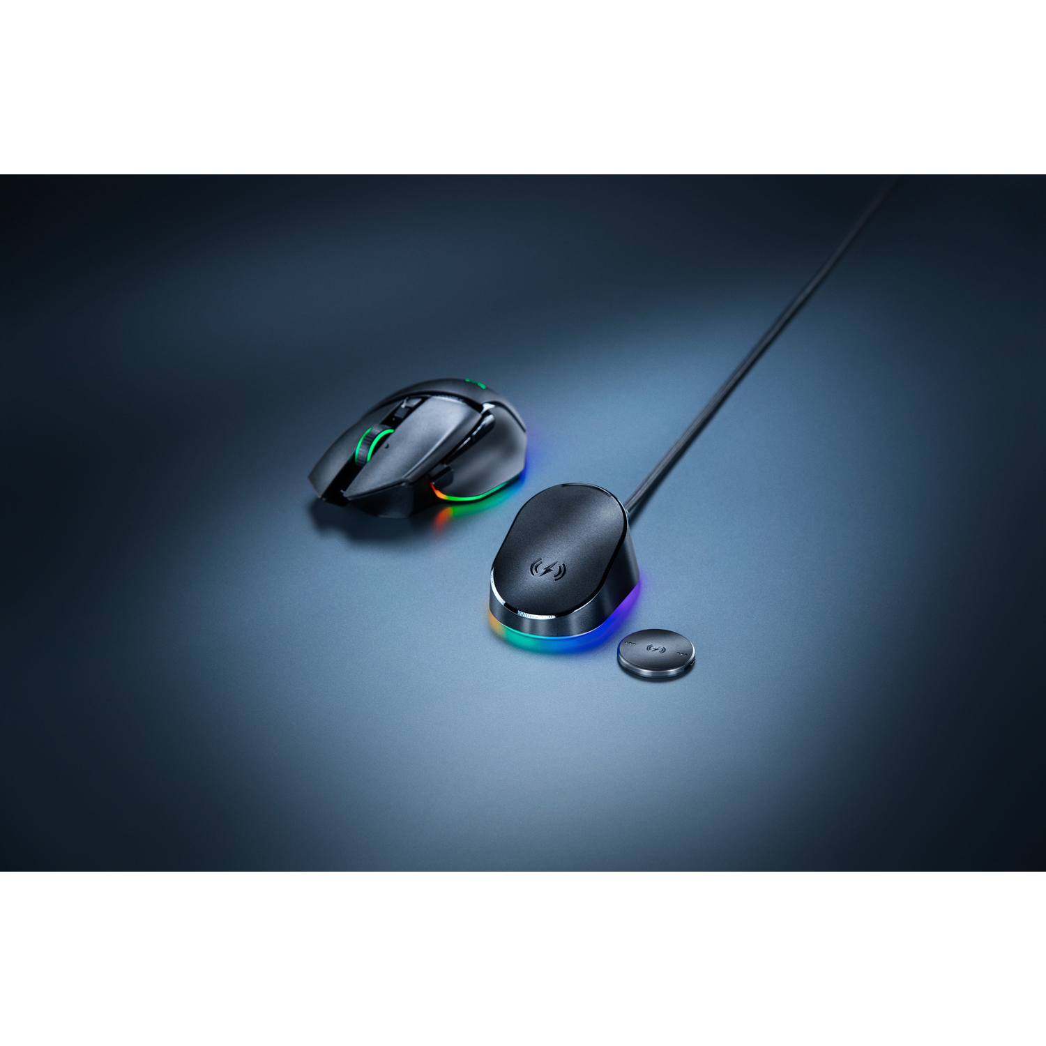 Souris noire avec éclairage RVB à côté d'une station de charge et d'un dongle.