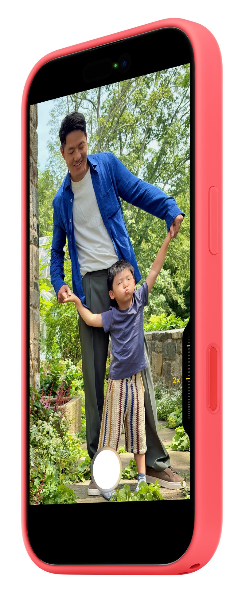 Mężczyzna i dziecko trzymają się za ręce w ogrodzie, dziecko robi nadąsaną minę.