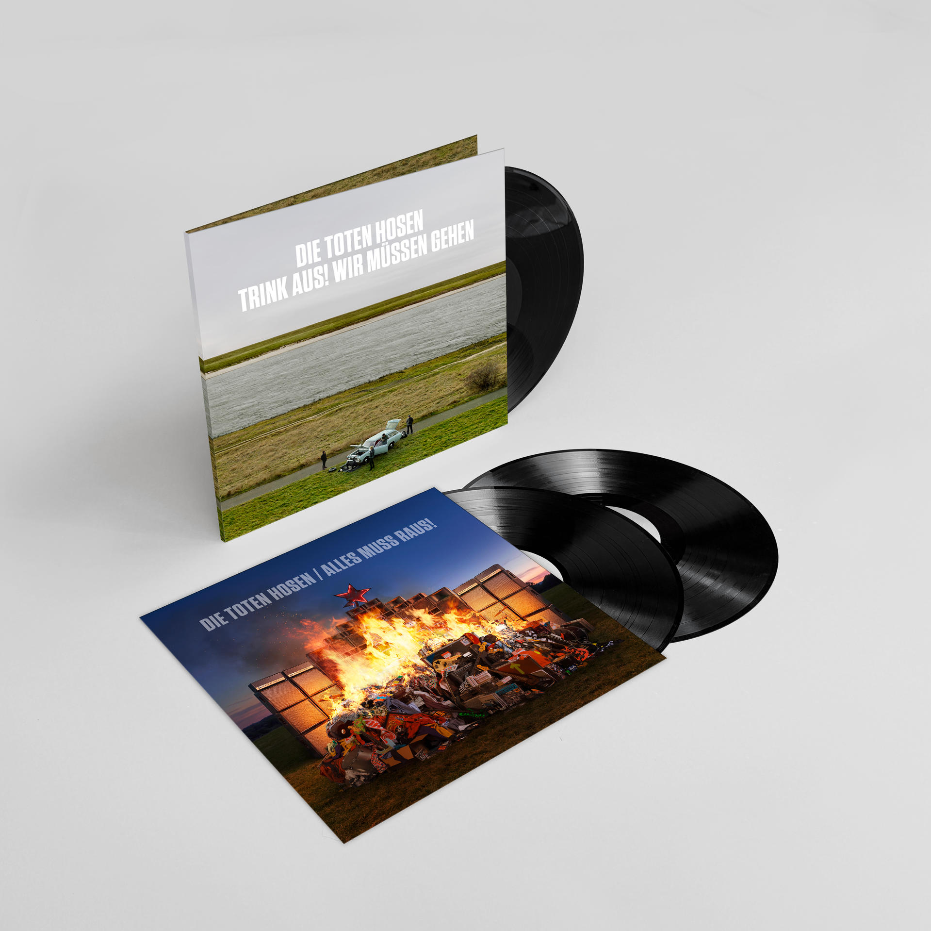Zwei Vinyl-Schallplatten mit Albumcovern. Eines zeigt eine Landschaft mit einem Auto und Personen.