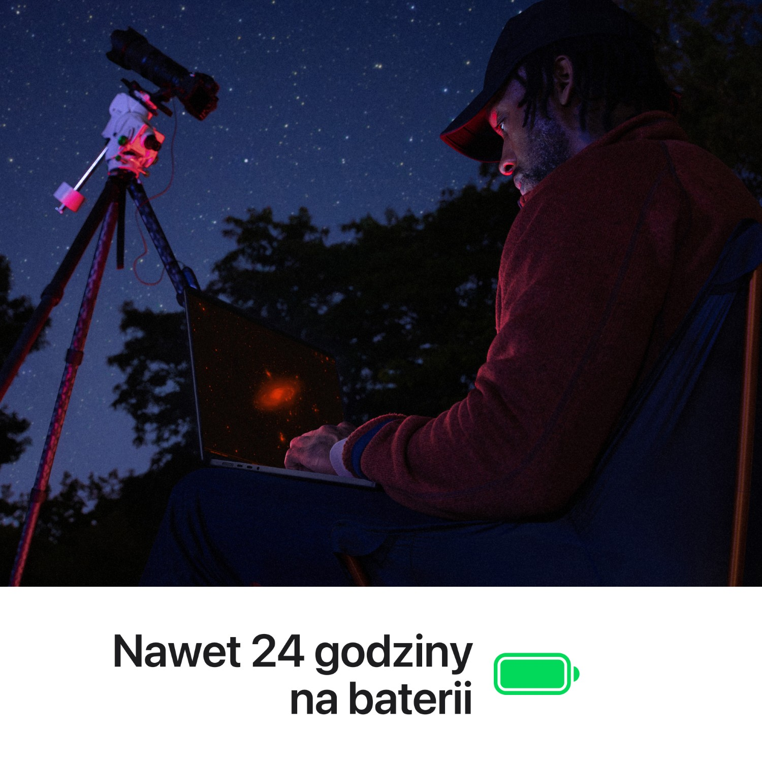 Mężczyzna z laptopem i teleskopem pod gwieździstym niebem.