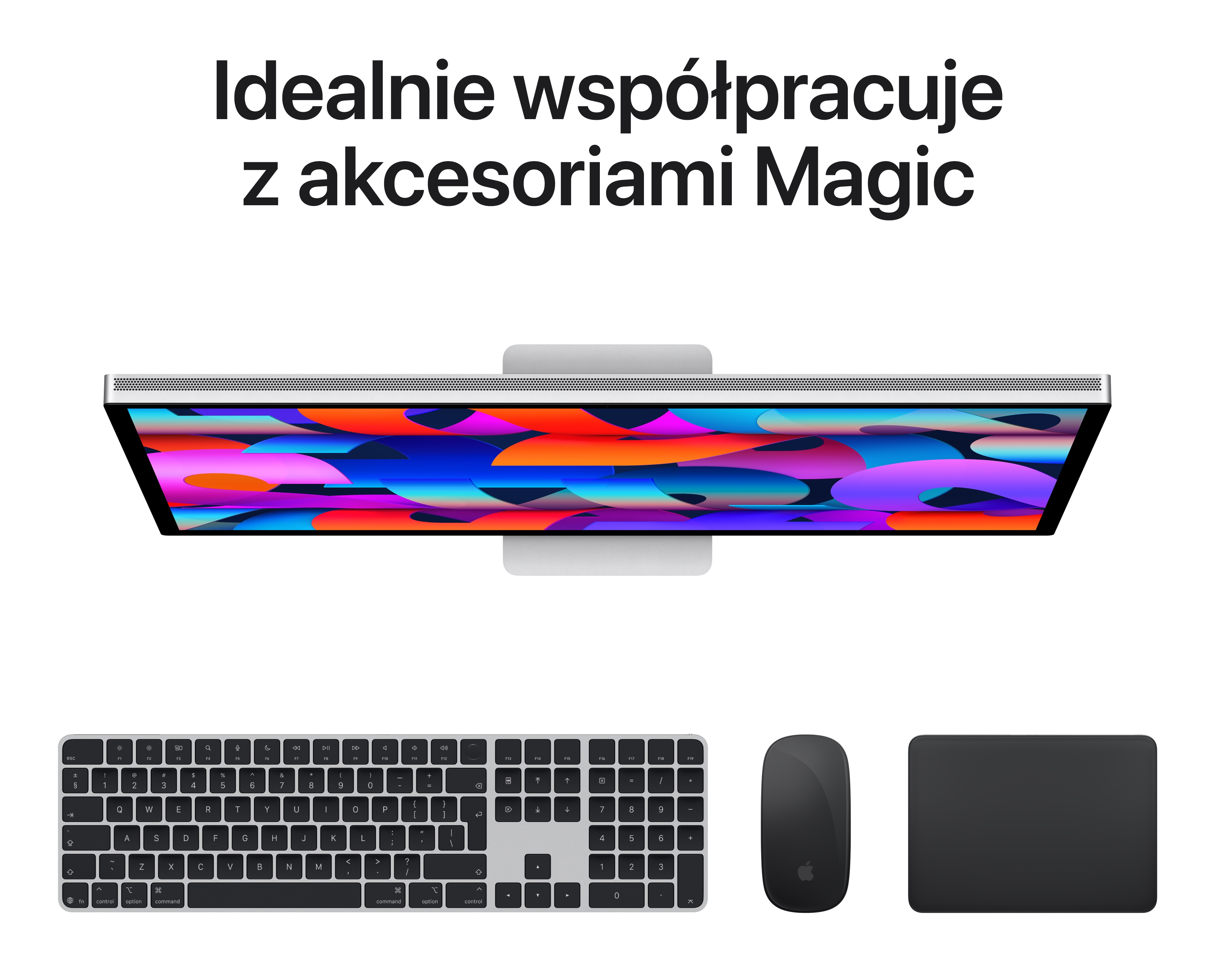 Komputer iMac z kolorową tapetą, klawiaturą, myszką i gładzikiem.