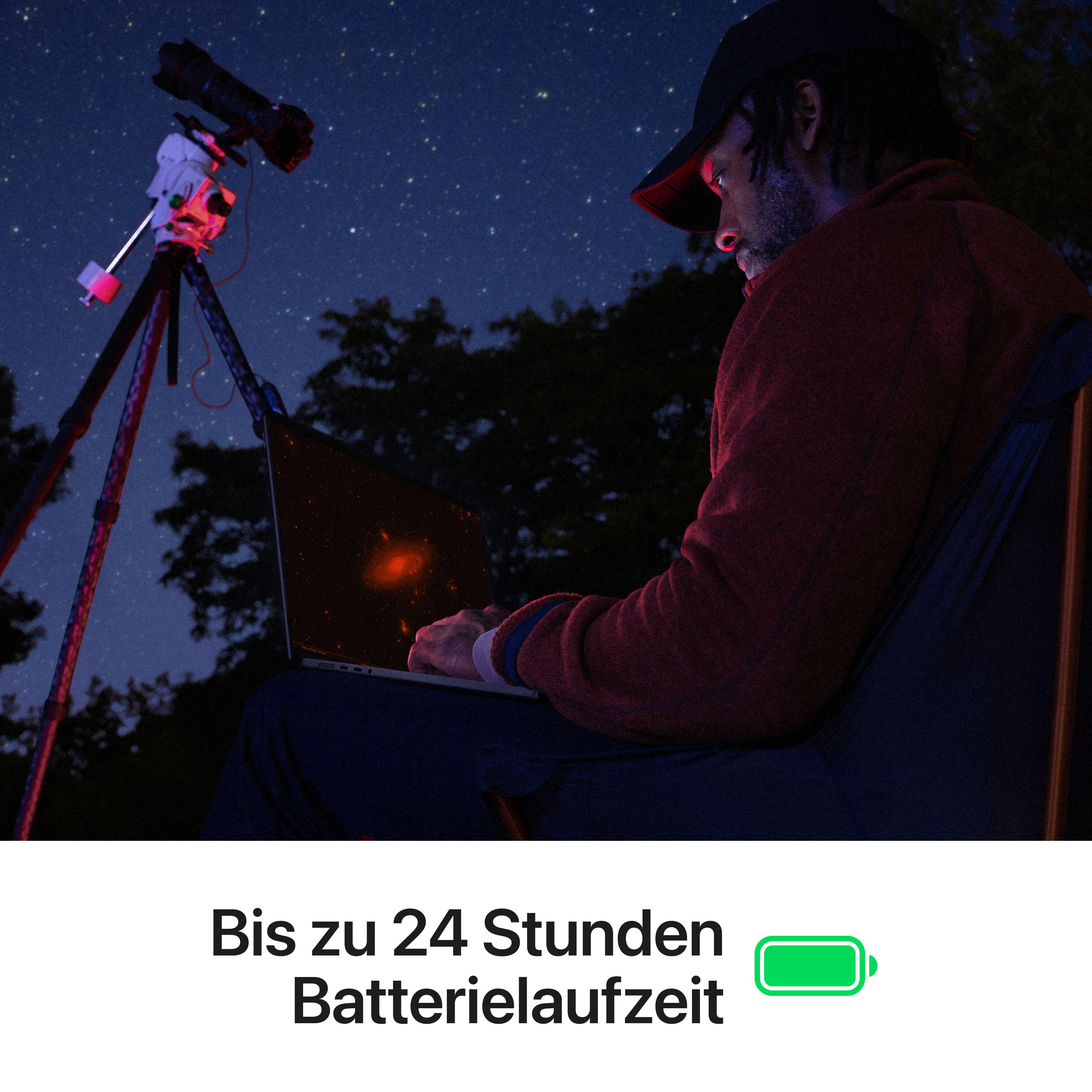 Mann mit Teleskop und Laptop unter Sternenhimmel.