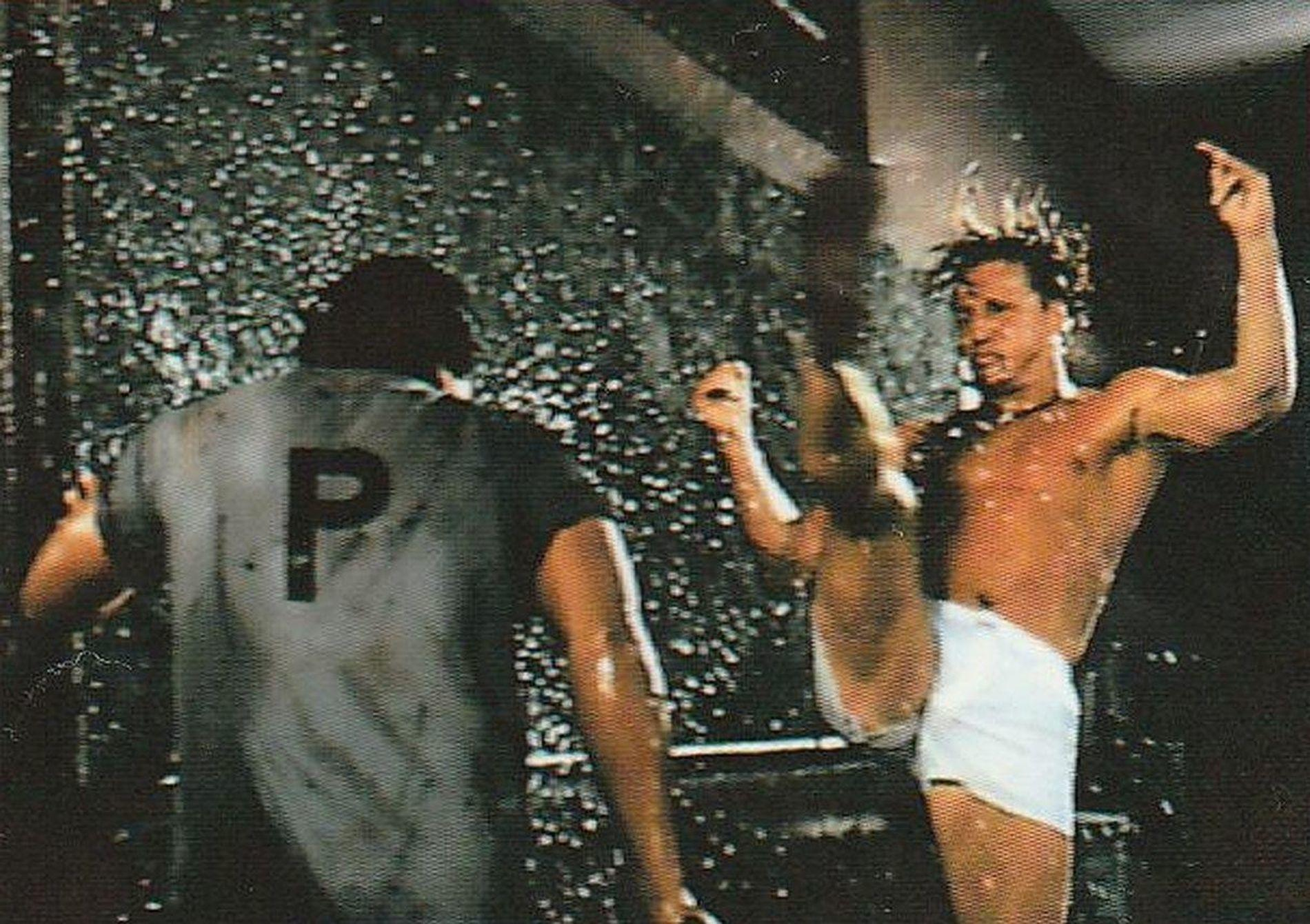 Zwei Männer kämpfen in einer Dusche mit vielen Wassertropfen.