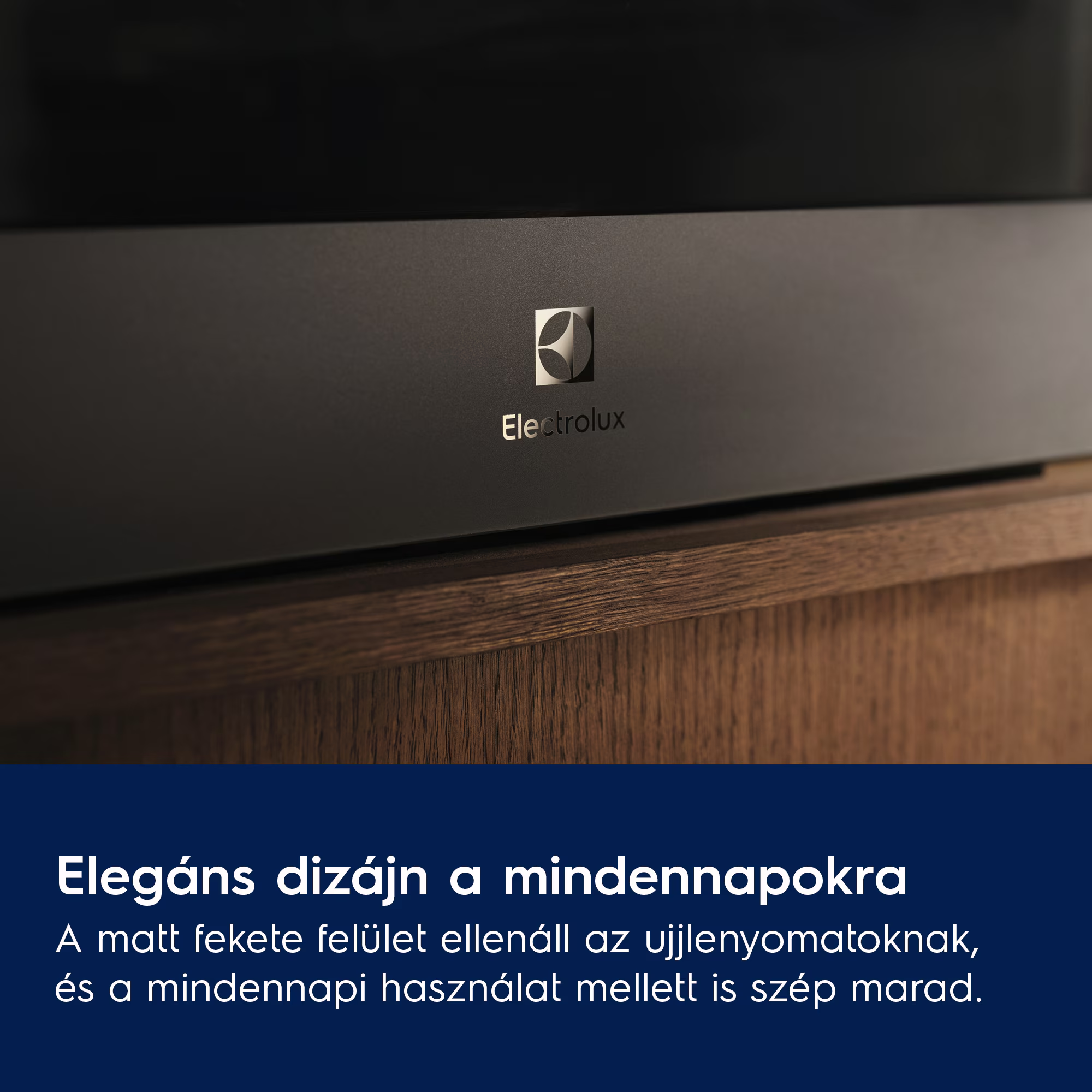 Sötét készülék, ezüst Electrolux logóval, fa felülettel, közelről.