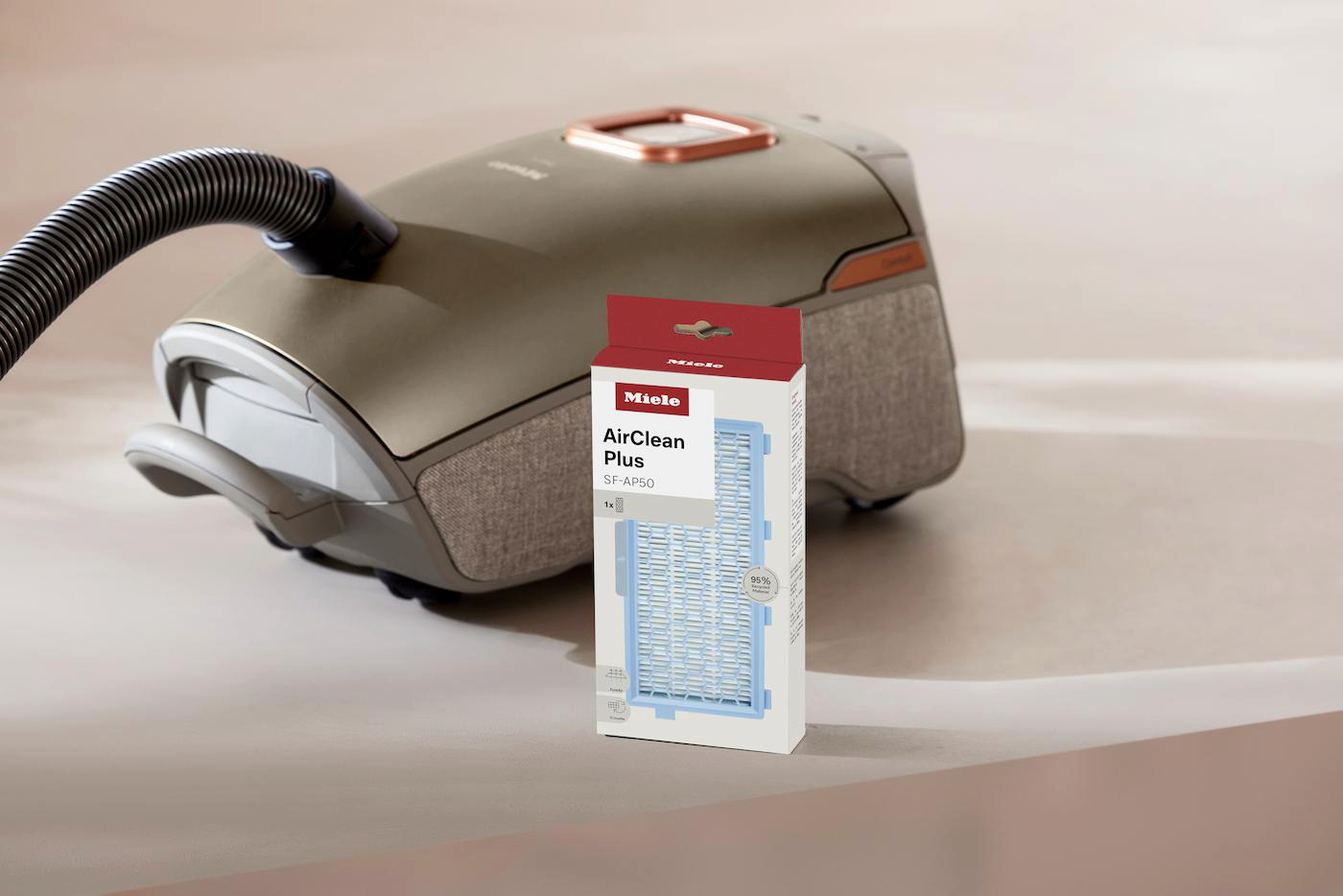 Ein Miele Staubsauger mit einem AirClean Plus Filterpaket daneben.