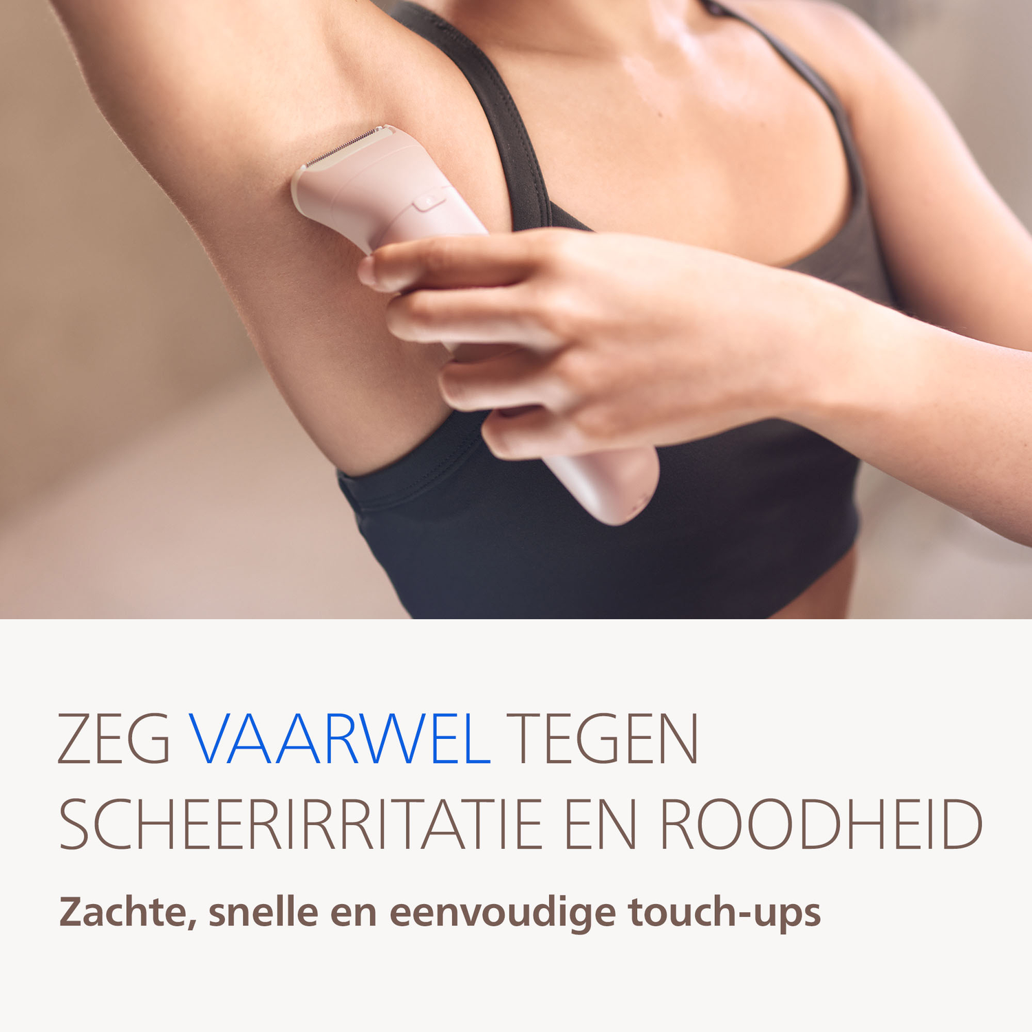 A woman is shaving her armpit with a pink epilator.