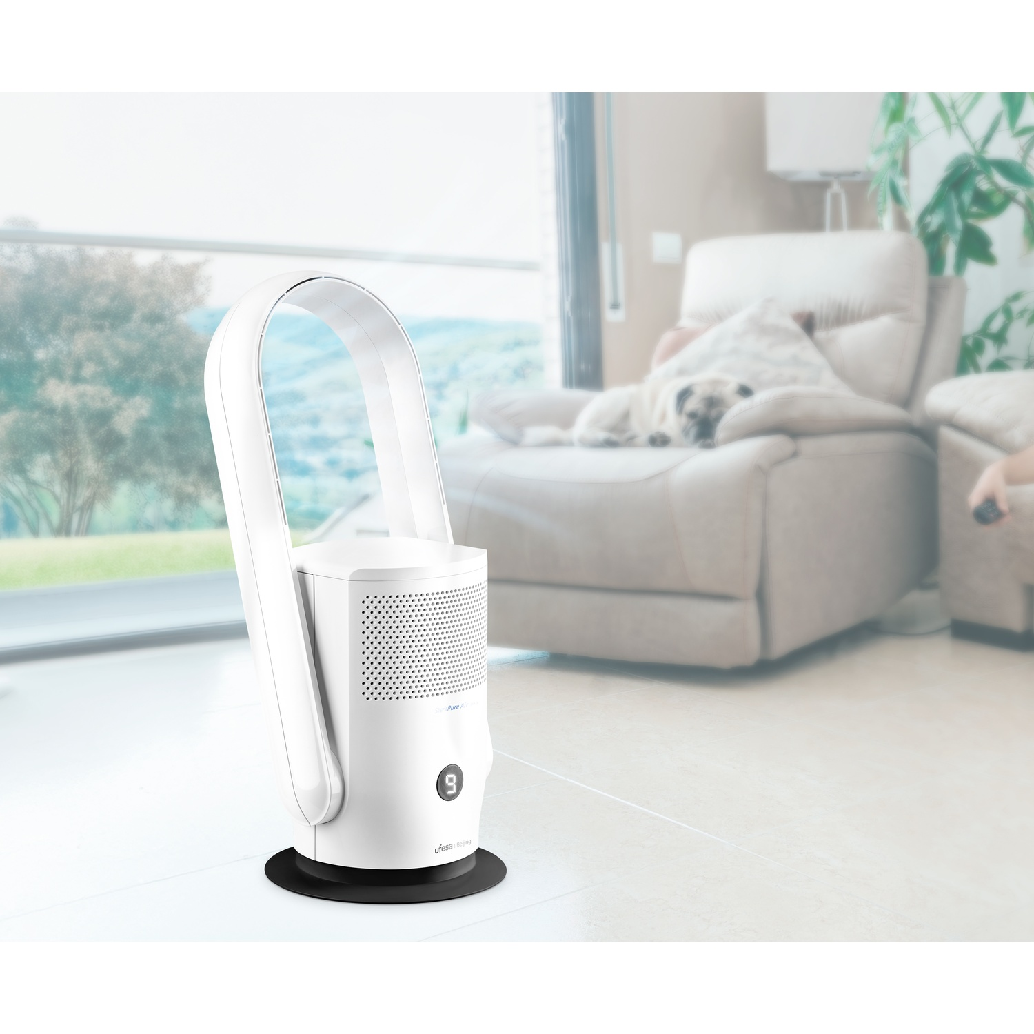 Ventilatore a torre bianco su pavimento chiaro. Un cane riposa su una poltrona.